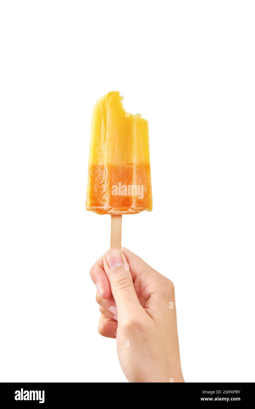 Donna tiene morso gelato giallo su sfondo bianco isolato. Colore popsicle di frutta surgelata. Foto Stock