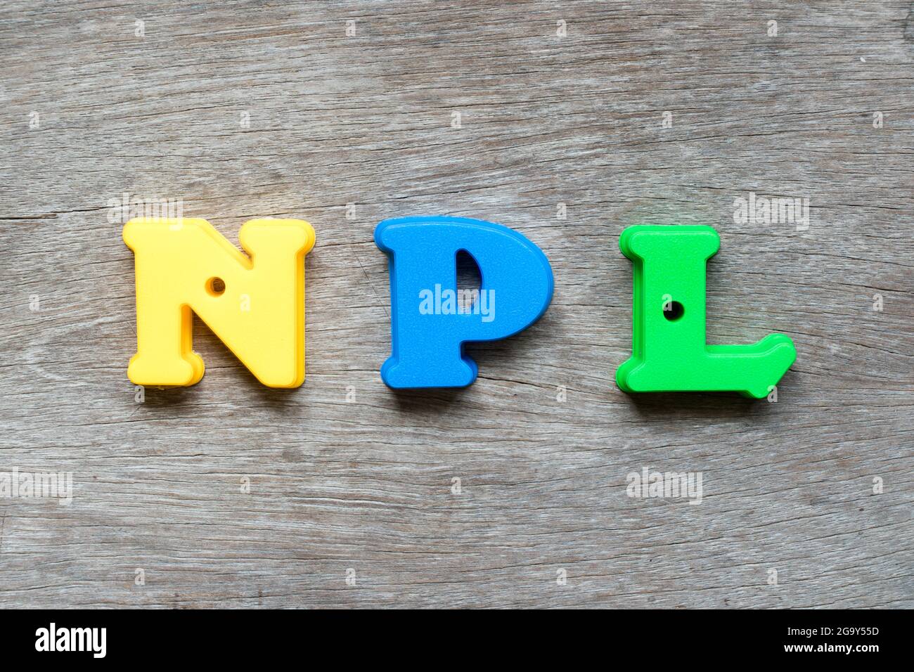 Alfabeto plastico colorato in parola NPL (Abbreviation of non Performing Loan, non-Patent Letterature) su sfondo di legno Foto Stock