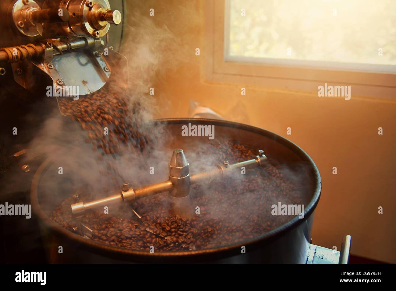 Primo piano di chicchi di caffè che tostano in una tostatura Foto Stock