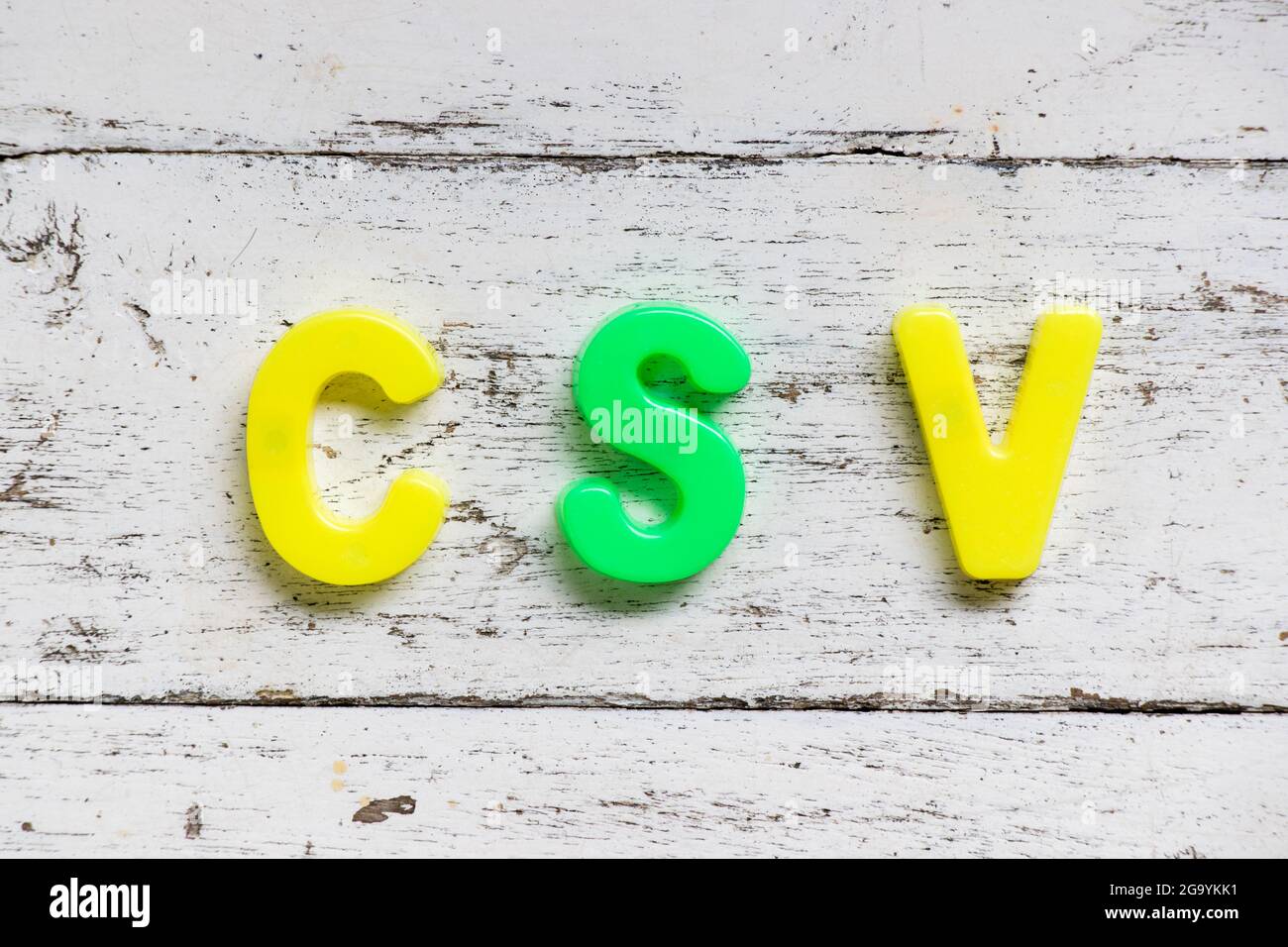 Alfabeto a colori in CSV di parole (Abbreviation of computer system validation or comma-Separated values) su sfondo di vecchio legno bianco grunge Foto Stock