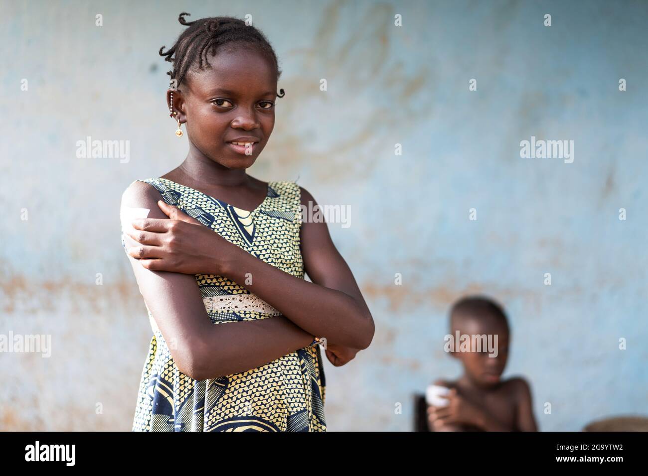 In questa immagine una bella studentessa nera in piedi con un sorriso sollevato sul suo viso sta premendo con forza le dita sul sito di iniezione coperto da Foto Stock