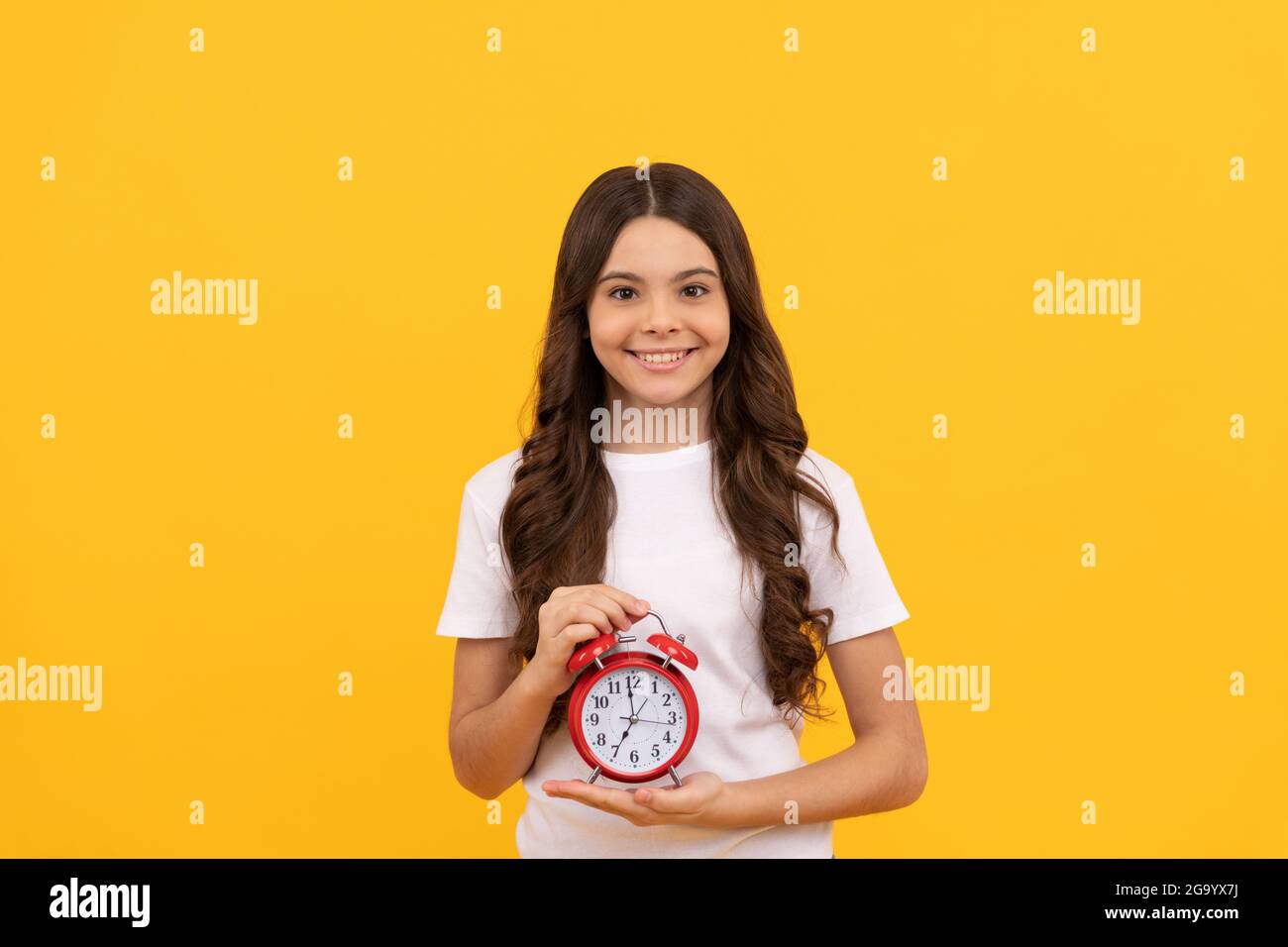 happy teen ragazza tenere retro sveglia che mostra l'ora, l'ora Foto Stock