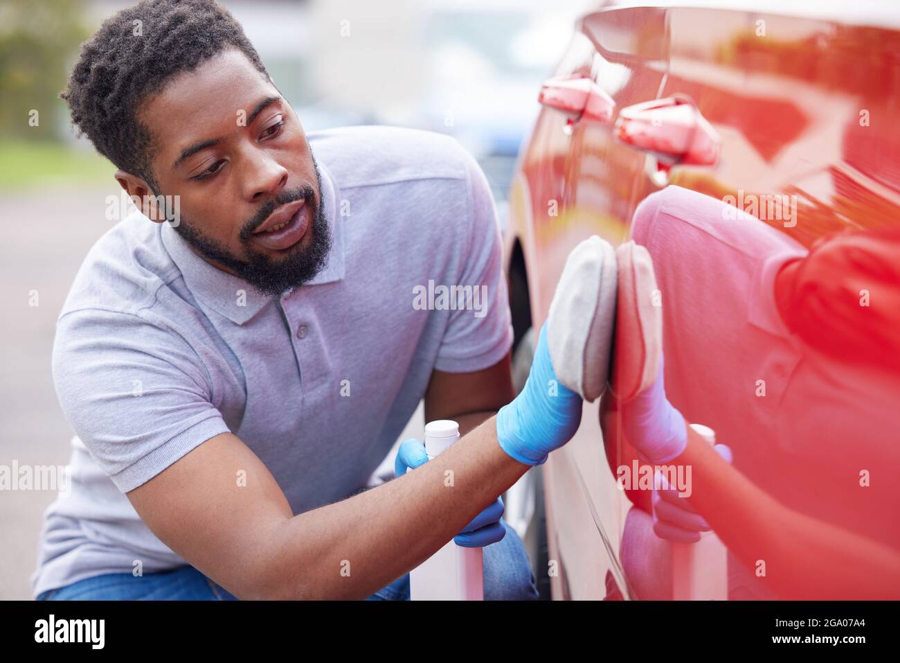 Uomo lucidatura Carrozzeria di auto durante Valet Foto Stock