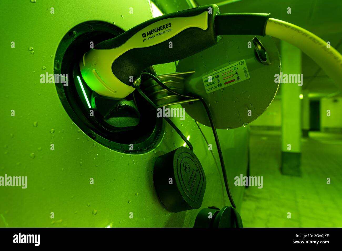 Ricarica di un'auto elettrica - luce verde per una ricarica di successo, scatto dettagliato del cavo Mennekes di tipo 2 collegato per un concetto di tendenza di e. Foto Stock