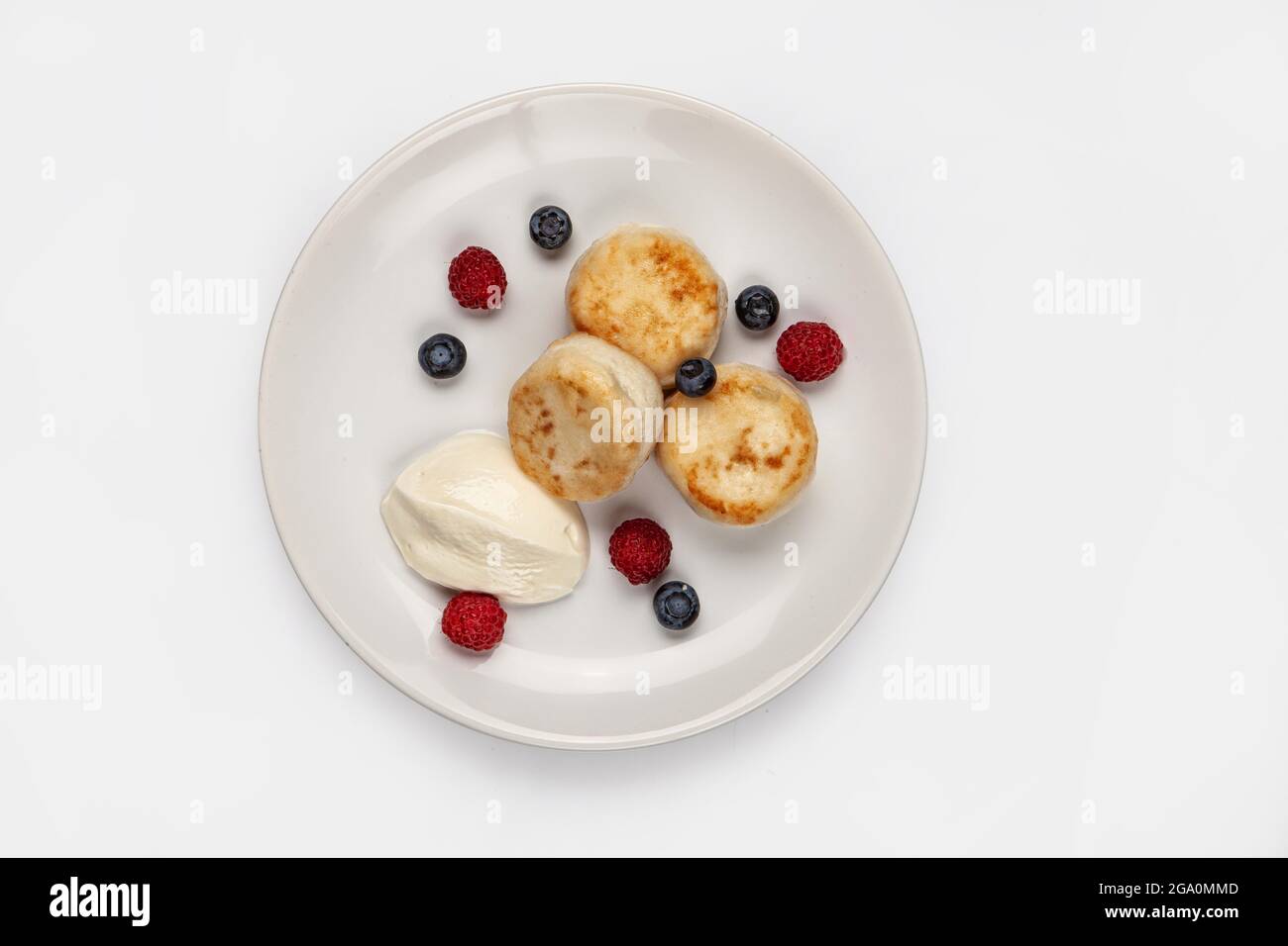 Torte di formaggio e bacche diverse su un piatto su uno sfondo isolato studio Foto Stock
