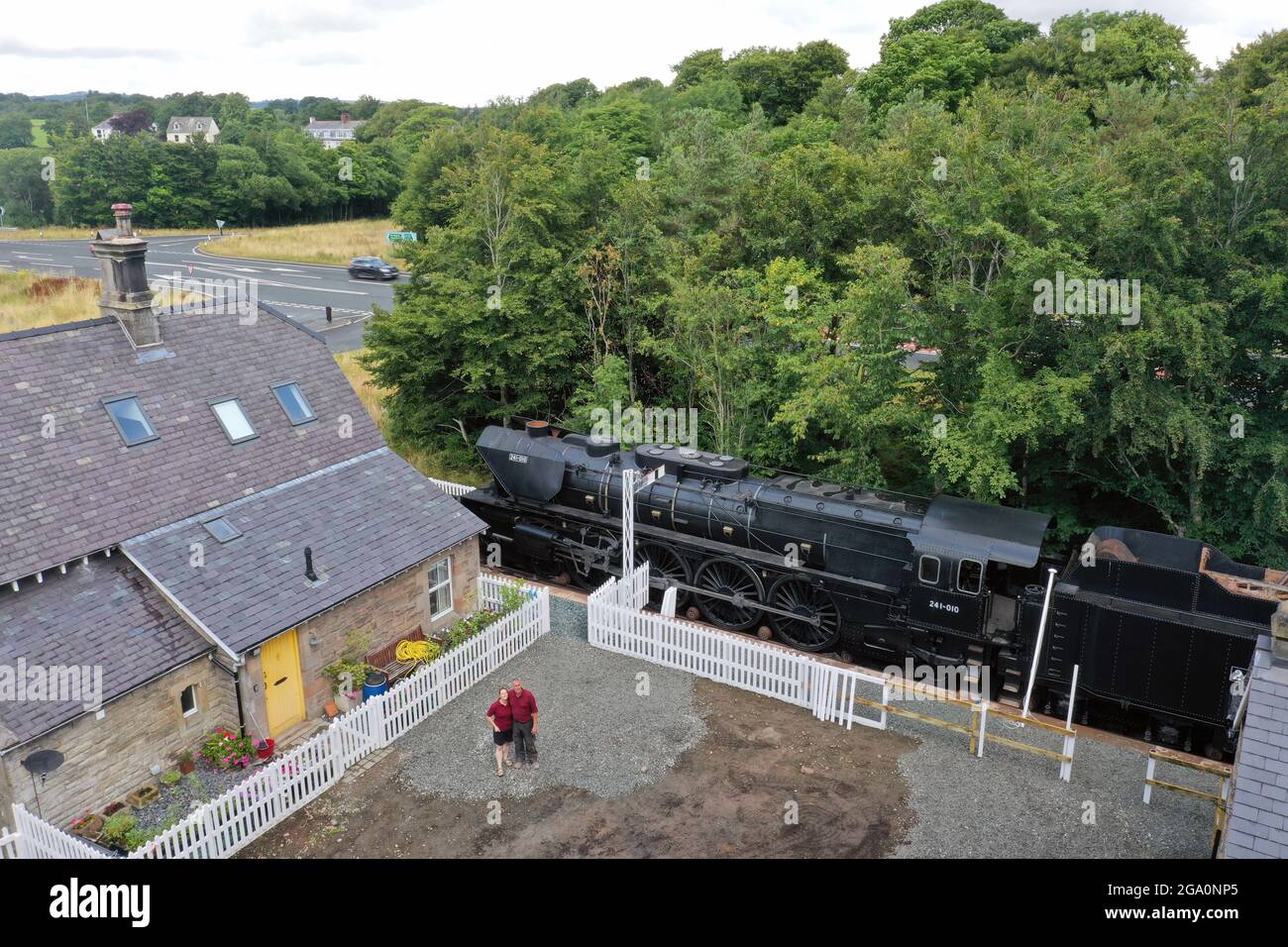 Simon e Diana Parums con il loro treno a vapore di dimensioni complete con carrozze, piste e piattaforma, mentre convertirono e restaurarono la stazione del lago Bassenthwaite a Keswick, offrendo un'esperienza culinaria su una carrozza ristorante di Hollywood come il suo pezzo forte, quando la aprono al pubblico come attrazione. Data immagine: Mercoledì 28 luglio 2021. Foto Stock