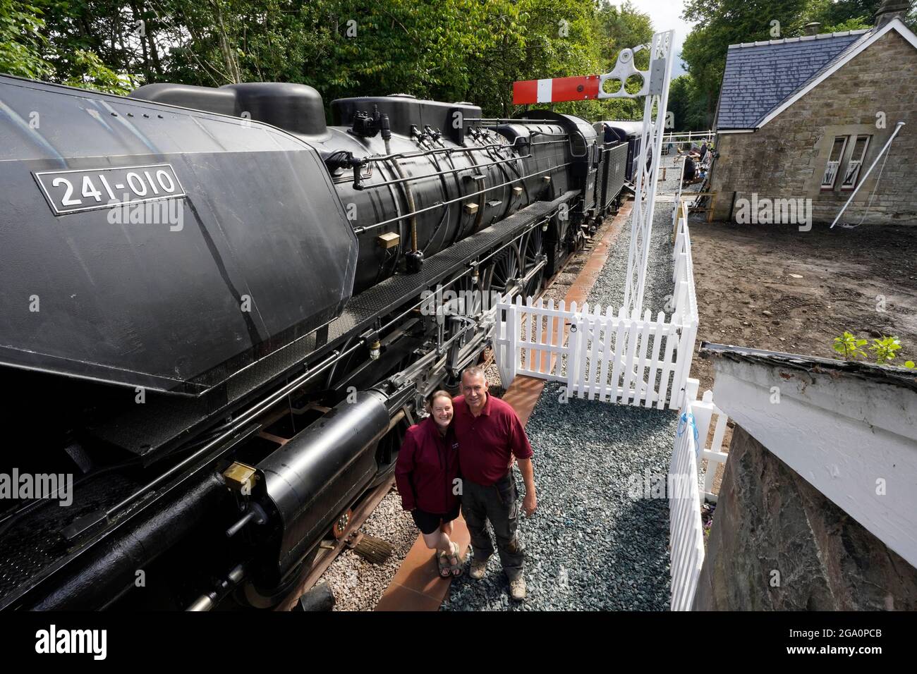 Simon e Diana Parums con il loro treno a vapore di dimensioni complete con carrozze, piste e piattaforma, mentre convertirono e restaurarono la stazione del lago Bassenthwaite a Keswick, offrendo un'esperienza culinaria su una carrozza ristorante di Hollywood come il suo pezzo forte, quando la aprono al pubblico come attrazione. Data immagine: Mercoledì 28 luglio 2021. Foto Stock