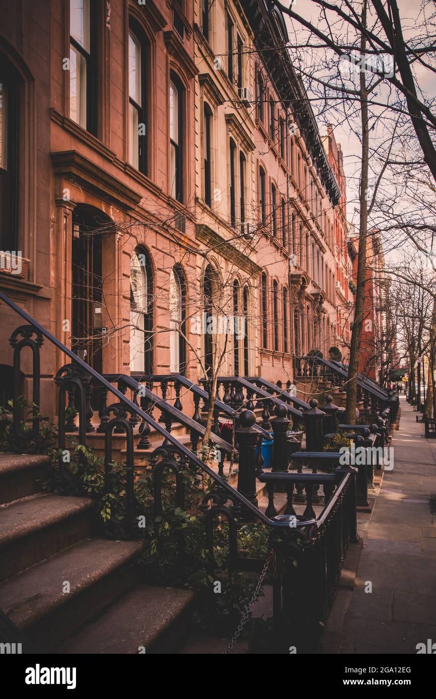 Fila di vecchi edifici di arenaria lungo un marciapiede vuoto blocco nel Greenwich Village quartiere di Manhattan, New York New York Foto Stock