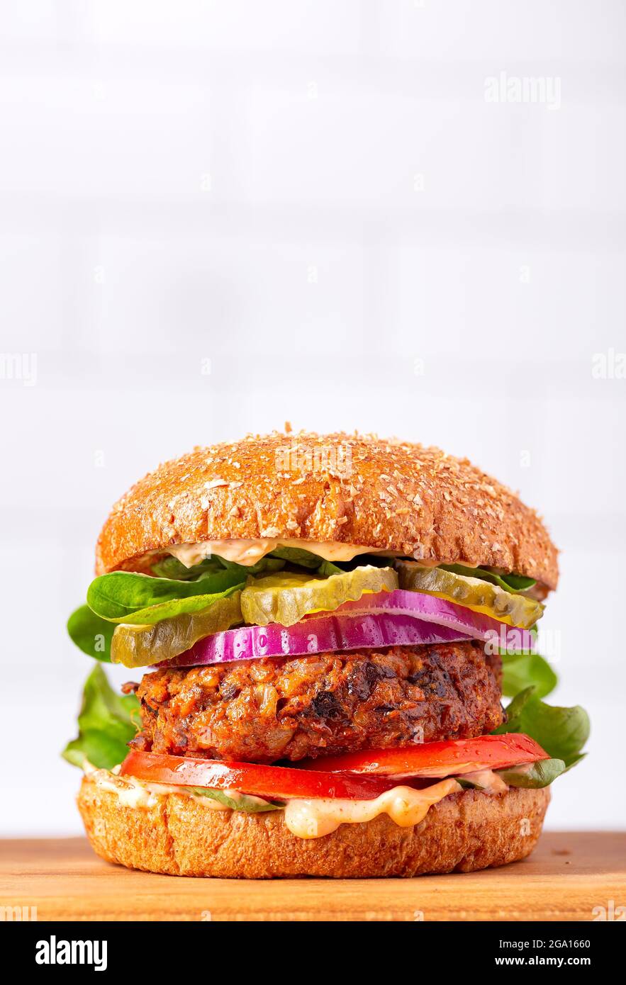 Hamburger fatto in casa a base di piante a base di patate dolci, fagioli neri e riso bruno su un panino integrale brioche; spazio copia Foto Stock