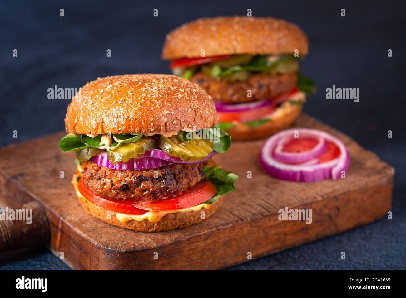 Due hamburger fatti in casa a base di piante a base di patate dolci, fagioli neri e riso bruno su un panino integrale brioche; spazio copia Foto Stock