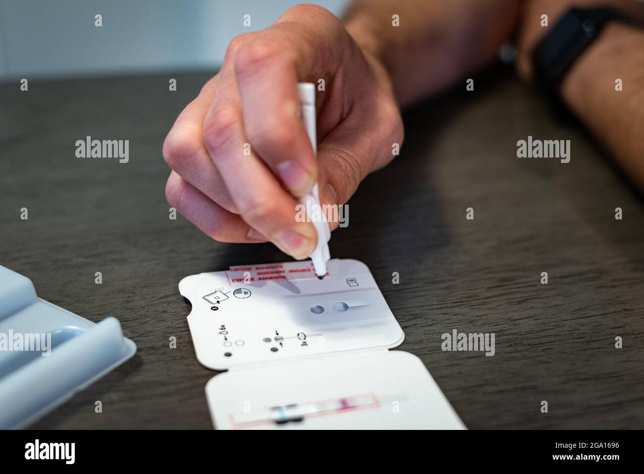 I kit di test per la casa di PCR COVID-19 stanno diventando sempre più importanti e accessibili, come dimostrato da questo uomo che sta effettuando un test presso la sua residenza. Foto Stock