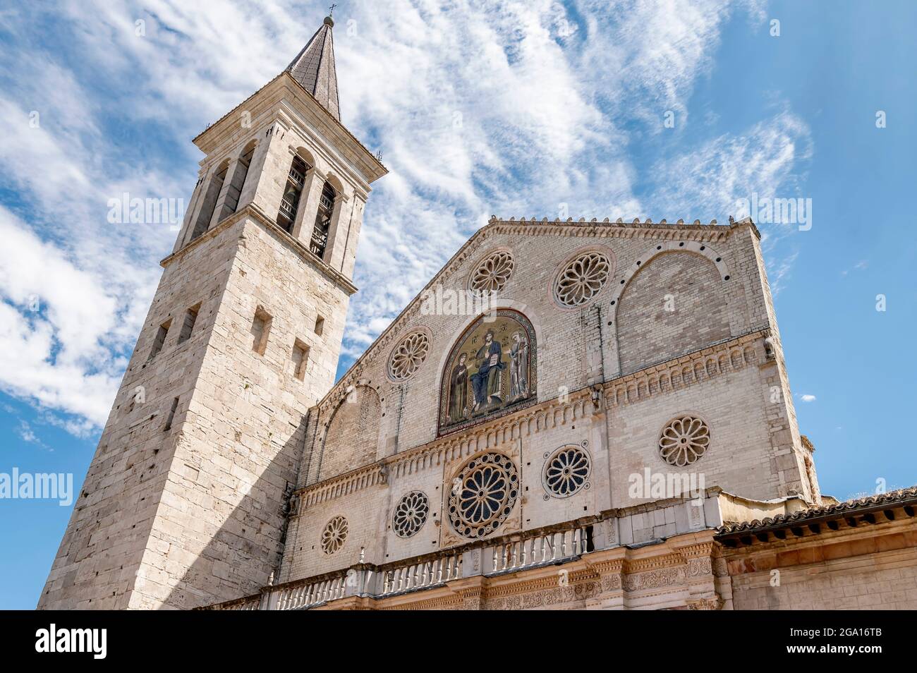 Un particolare della bella facciata dell'antica cattedrale del Duomo di Santa Maria Assunta a Spoleto, in Italia, contro un cielo drammatico Foto Stock