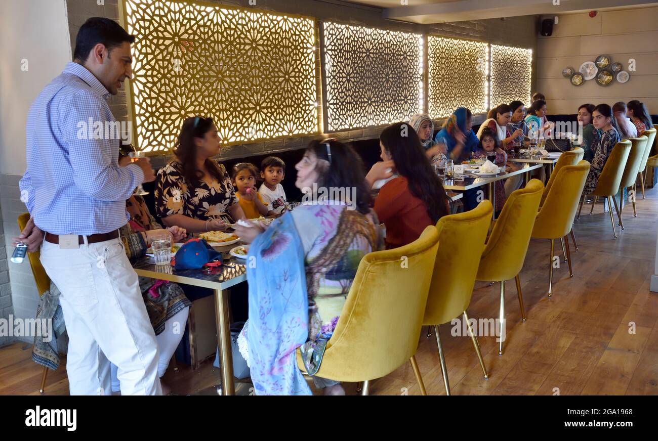 All'interno del ristorante indiano le famiglie mangiano ai tavoli Foto Stock