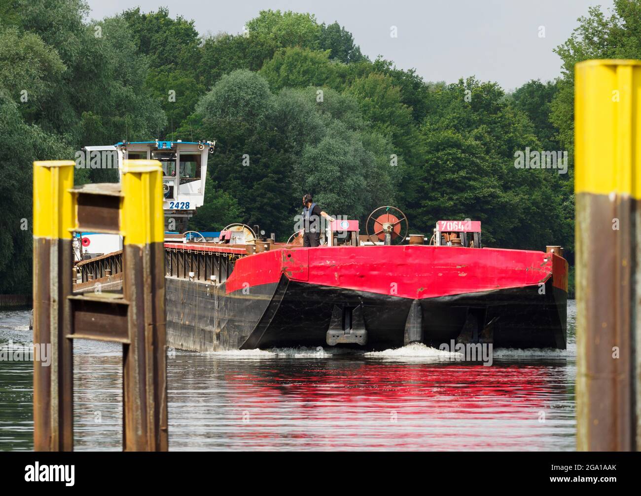 Kleinmachnow, Germania. 22 luglio 2021. Il dispositivo di spinta del canale SCH 2428 naviga nel canale Teltow verso il dispositivo di bloccaggio Kleinmachnower. Il canale Teltow corre per circa 38 chilometri attraverso Brandeburgo e Berlino ed è un importante bypass del sud di Berlino per il trasporto commerciale e una destinazione popolare per i campeggiatori, i turisti in barca e anche gli escursionisti. A Dreilinden, per esempio, ci sono più o meno stretti sentieri per pedoni vicino alla riva del canale fino a Machnower See. Credit: Soeren Stache/dpa-Zentralbild/ZB/dpa/Alamy Live News Foto Stock