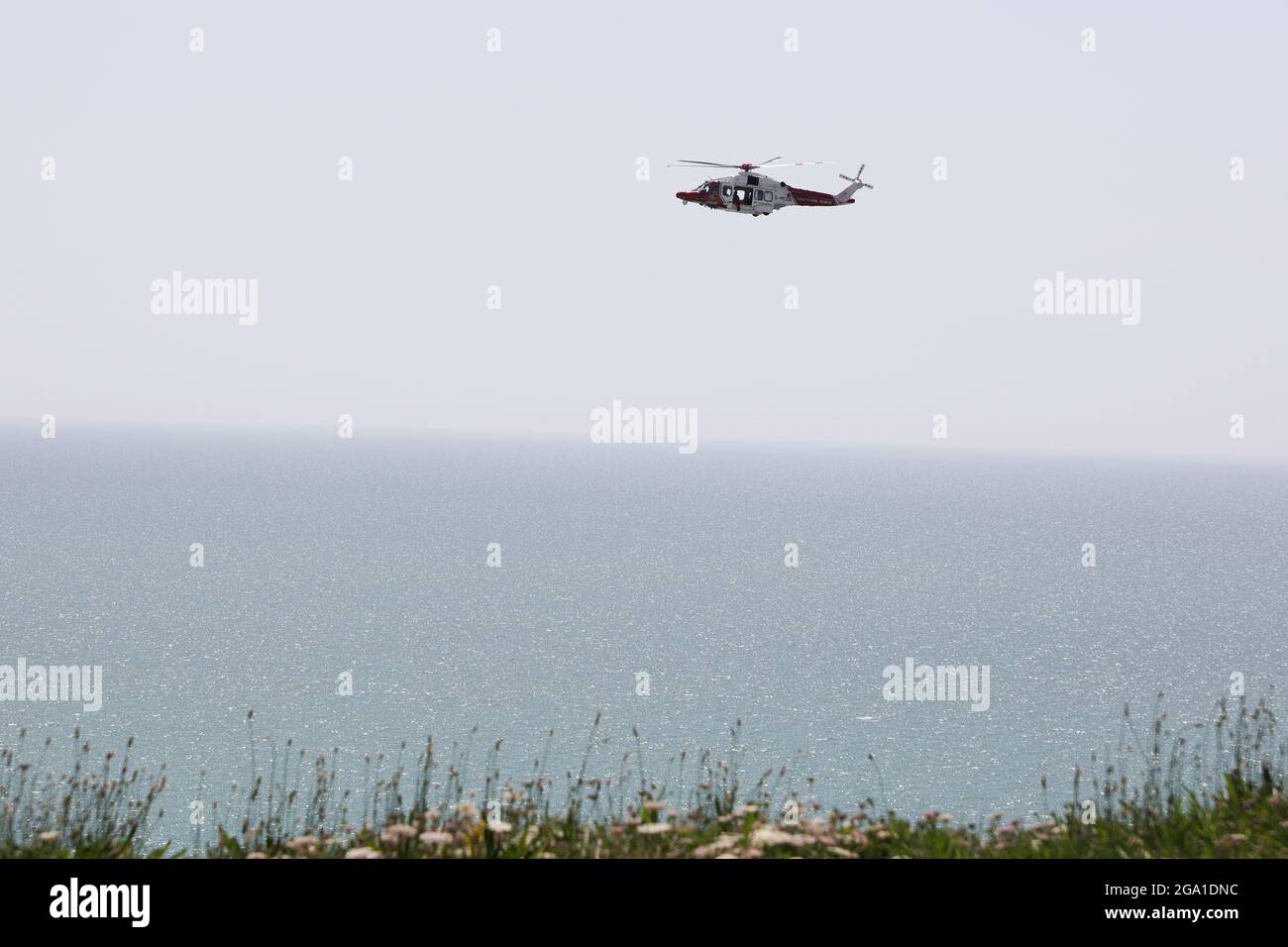 Elicottero con guardia costiera sopra Seaford Head Foto Stock