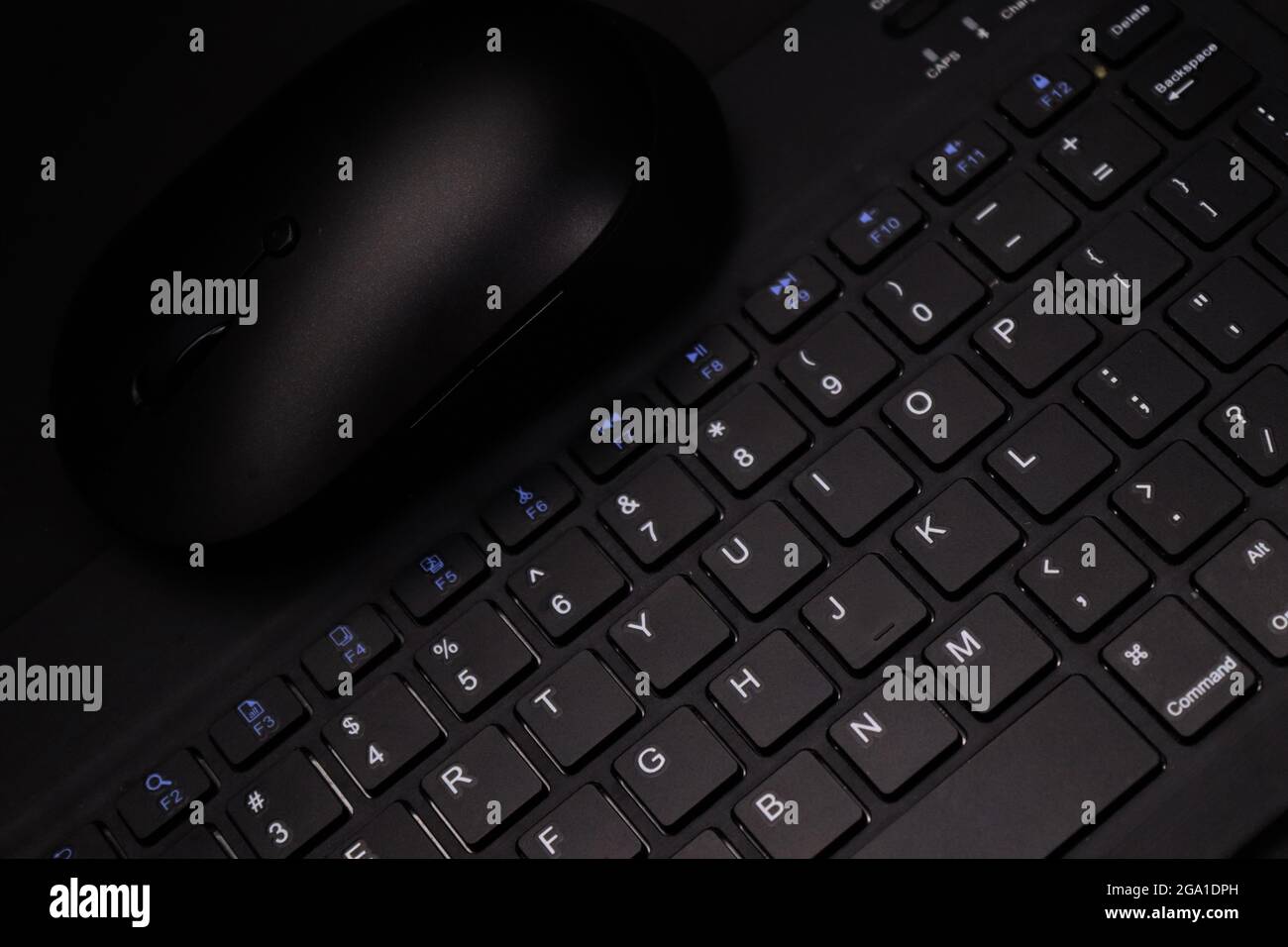 Elegante mouse wireless nero sulla tastiera wireless nera su sfondo orizzontale e nero Foto Stock