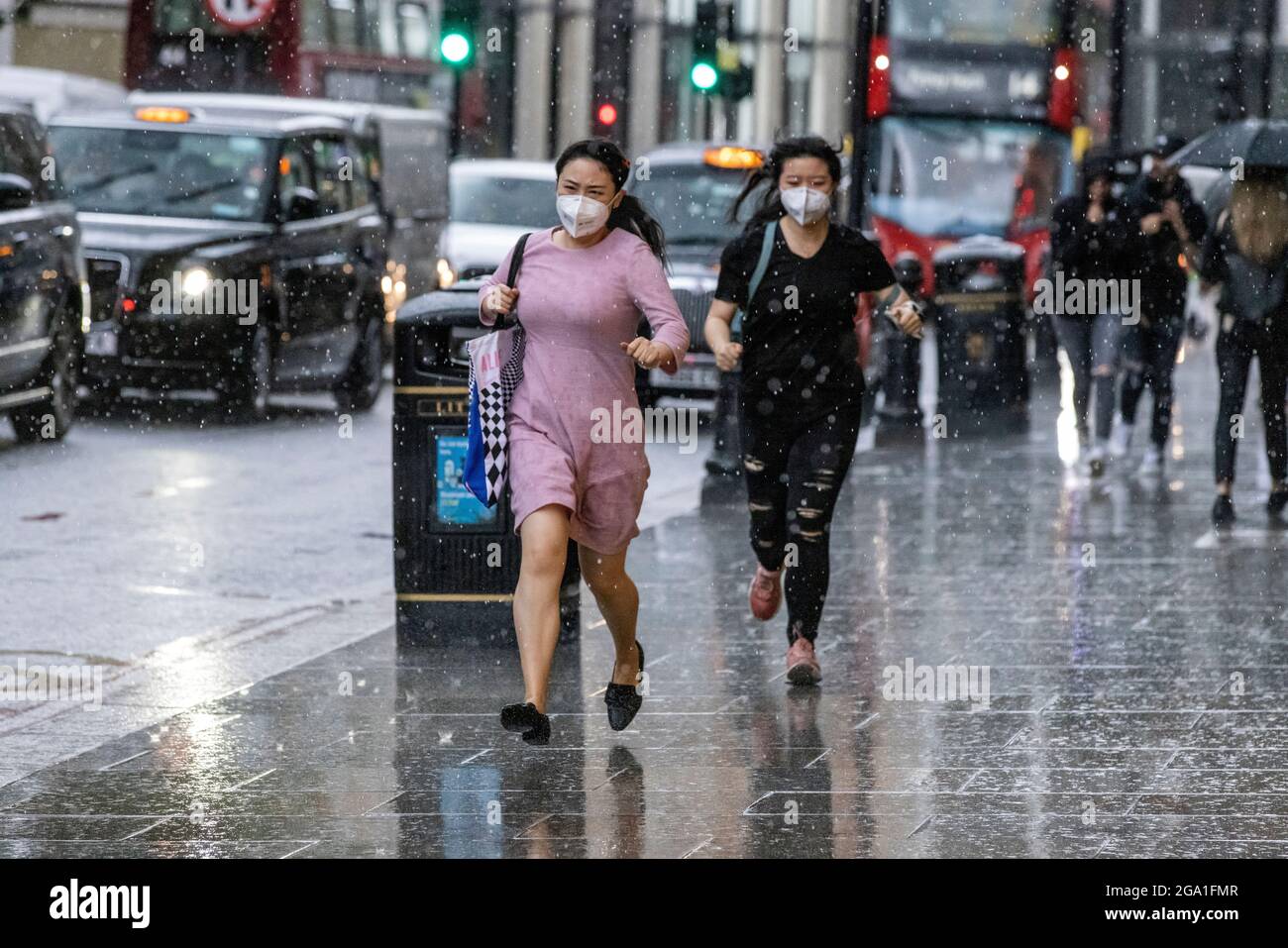 Londra, Regno Unito. Luglio 28 2021: Heavy Rain Showers Hit Knightsbridge, Central London, England, UK Picture mostra i turisti che corrono per coprire la pioggia, mentre le forti piogge si spostano attraverso il centro di Londra e le parti meridionali dell'Inghilterra. Credito: Clickpics/Alamy Live News Foto Stock