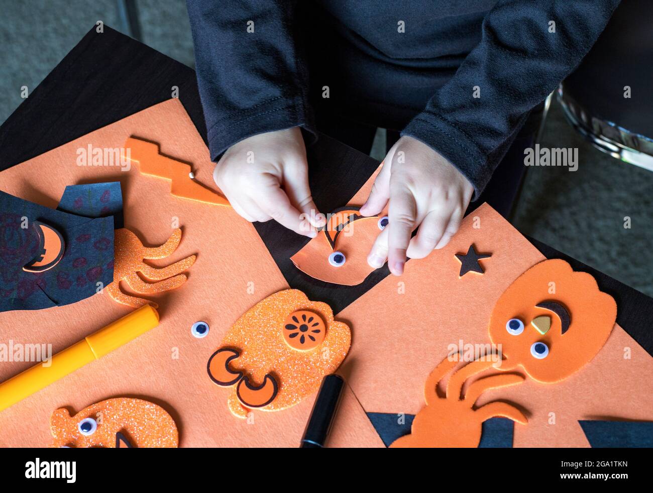 Halloween bambini preparati artigianali. Piccolo bambino che fa mestieri autunnali. Concetto di festa fai da te per i bambini di Halloween. Foto Stock