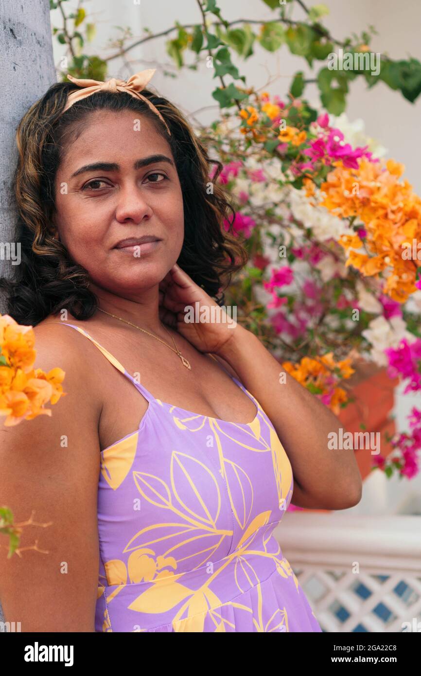 Bella donna di 40 anni che fissa i suoi capelli in strada Foto Stock