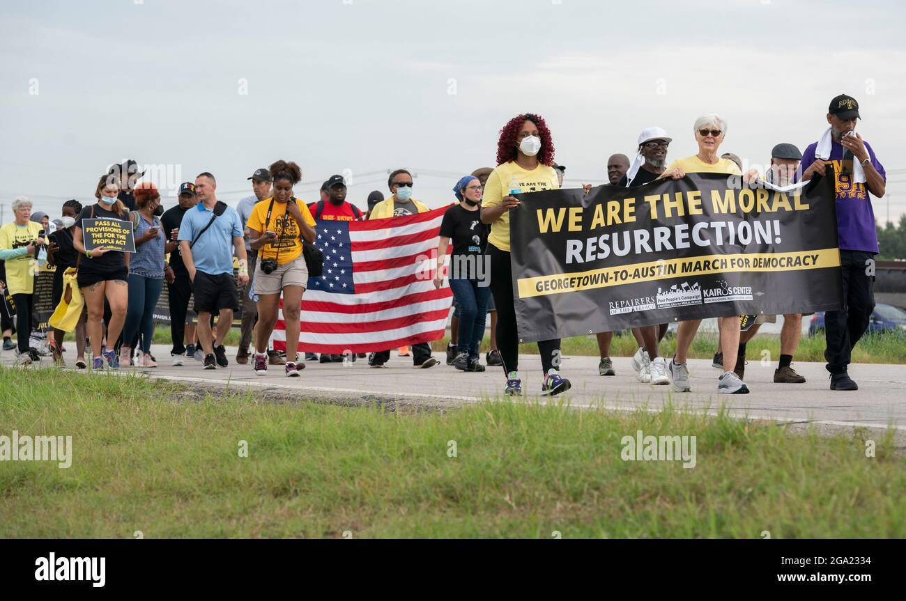 Georgetown, Stati Uniti. 28 luglio 2021. Gli attivisti per i diritti di voto nazionali e del Texas che detengono il banner "We are the Moral Resurrection" iniziano una marcia di 30 miglia, quattro giorni, da Georgetown, Texas, al Campidoglio di Stato di Austin. A causa del caldo estivo del Texas, diversi turni da 100 persone si scambieranno di marcia per circa 4 miglia ciascuno. La marcia per la democrazia sollecita l'approvazione della legge sui diritti di voto di John Lewis e l'eliminazione delle barriere statali al voto. Credit: Bob Daemmrich/Alamy Live News Foto Stock