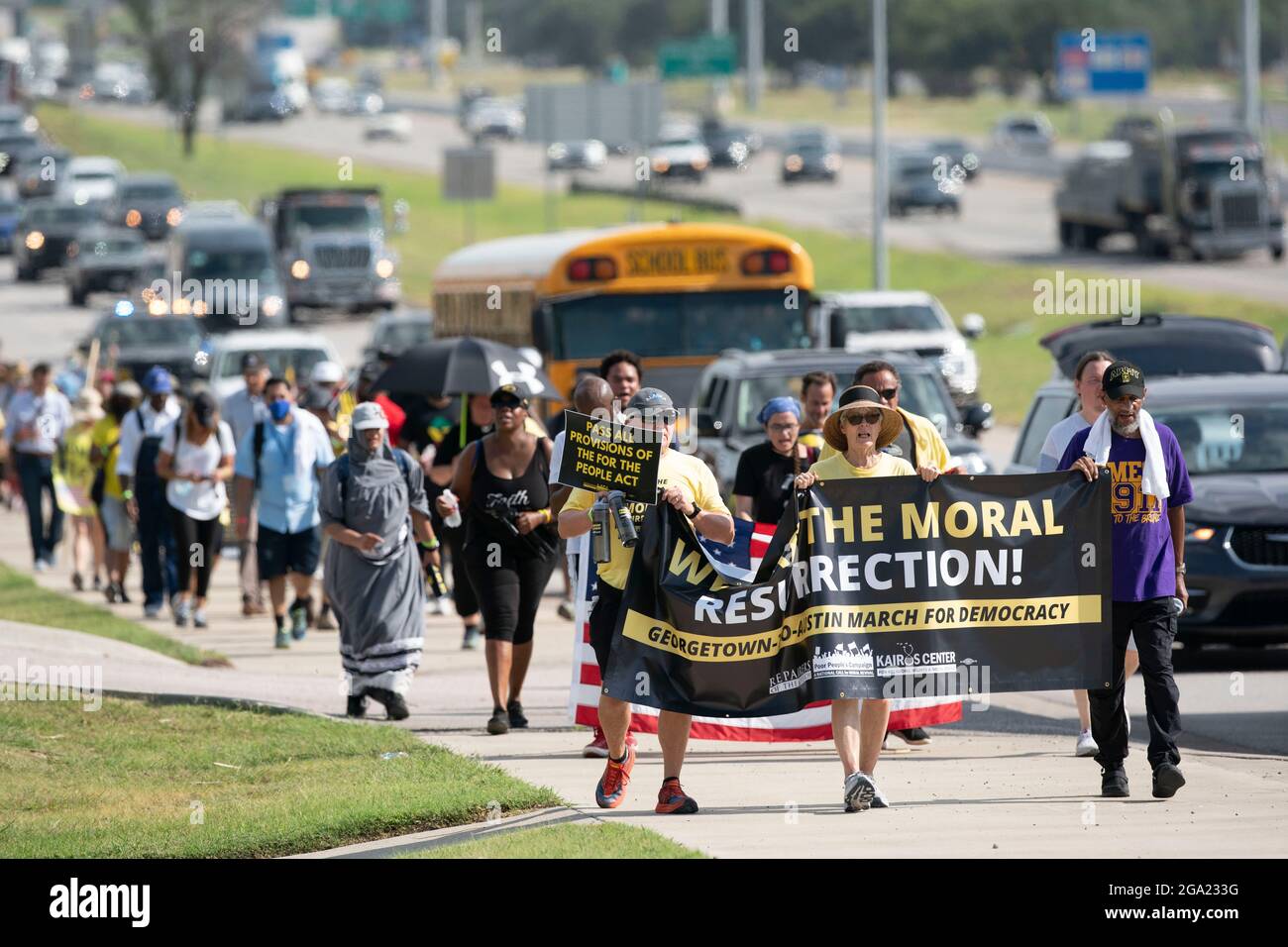 Georgetown, Stati Uniti. 28 luglio 2021. I gruppi nazionali e dei diritti di voto del Texas iniziano una marcia di 30 miglia, quattro giorni lungo una strada di servizio dell'autostrada interstatale da Georgetown, Texas, al Campidoglio di Stato ad Austin. A causa del caldo estivo del Texas, diversi turni da 100 persone si scambieranno di marcia per circa 4 miglia ciascuno. La marcia per la democrazia sollecita l'approvazione della legge sui diritti di voto di John Lewis e l'eliminazione delle barriere statali al voto. Credit: Bob Daemmrich/Alamy Live News Foto Stock