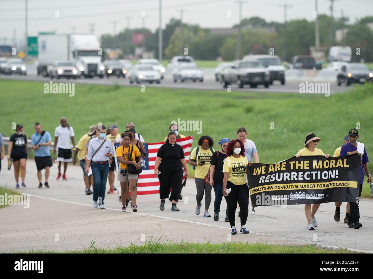 Georgetown, Stati Uniti. 28 luglio 2021. Gli attivisti per i diritti di voto nazionali e del Texas che detengono il banner "We are the Moral Resurrection" iniziano una marcia di 30 miglia, quattro giorni, da Georgetown, Texas, al Campidoglio di Stato di Austin. A causa del caldo estivo del Texas, diversi turni da 100 persone si scambieranno di marcia per circa 4 miglia ciascuno. La marcia per la democrazia sollecita l'approvazione della legge sui diritti di voto di John Lewis e l'eliminazione delle barriere statali al voto. Credit: Bob Daemmrich/Alamy Live News Foto Stock
