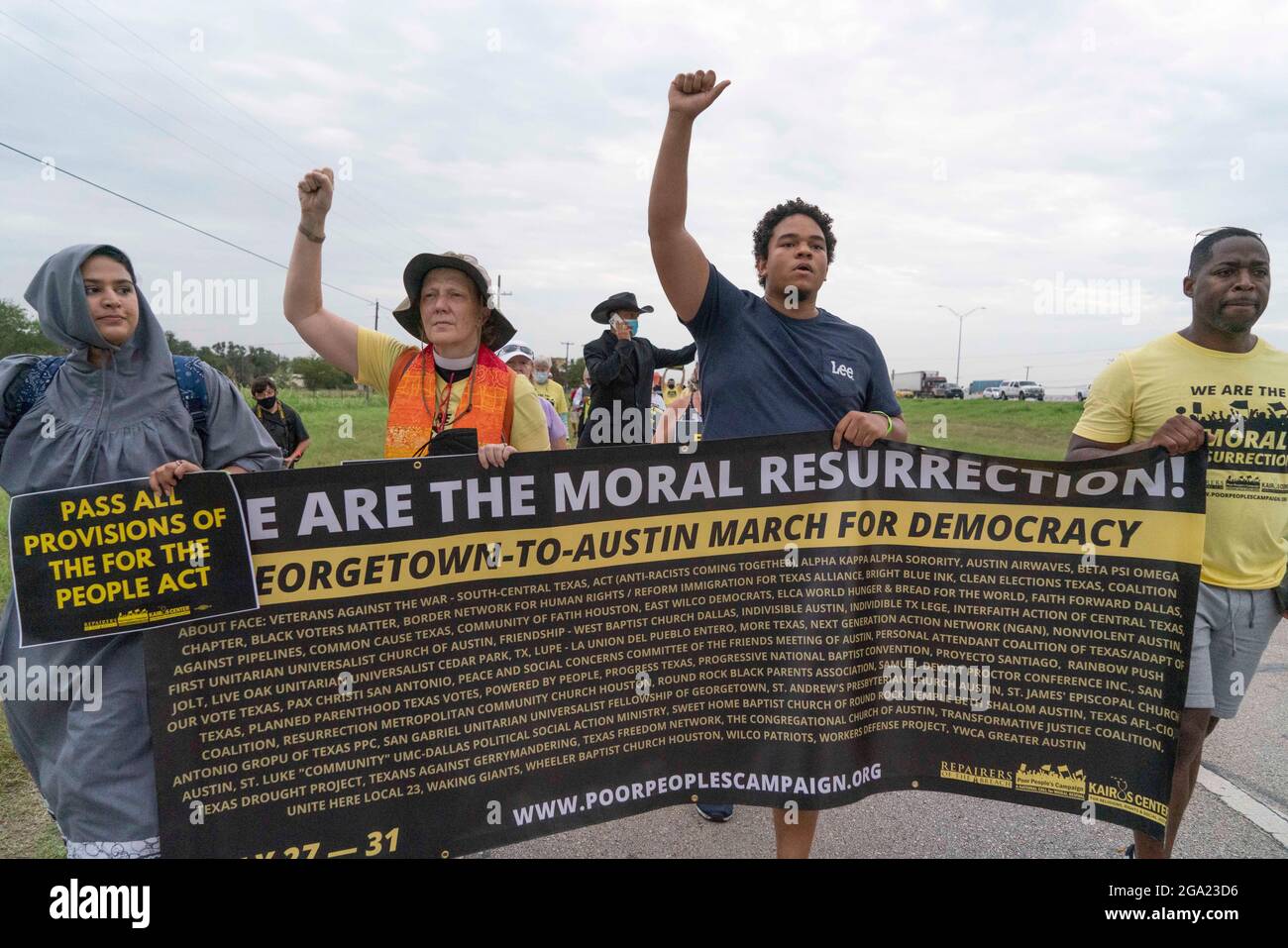 Georgetown, Stati Uniti. 28 luglio 2021. Gli attivisti per i diritti di voto nazionali e del Texas che detengono il banner "We are the Moral Resurrection" iniziano una marcia di 30 miglia, quattro giorni, da Georgetown, Texas, al Campidoglio di Stato di Austin. A causa del caldo estivo del Texas, diversi turni da 100 persone si scambieranno di marcia per circa 4 miglia ciascuno. La marcia per la democrazia sollecita l'approvazione della legge sui diritti di voto di John Lewis e l'eliminazione delle barriere statali al voto. Credit: Bob Daemmrich/Alamy Live News Foto Stock