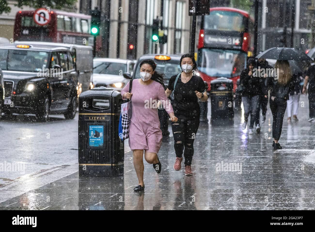 I turisti corrono per la copertura durante una pesante caduta di pioggia a Knightsbridge, Londra centrale, Regno Unito Foto Stock