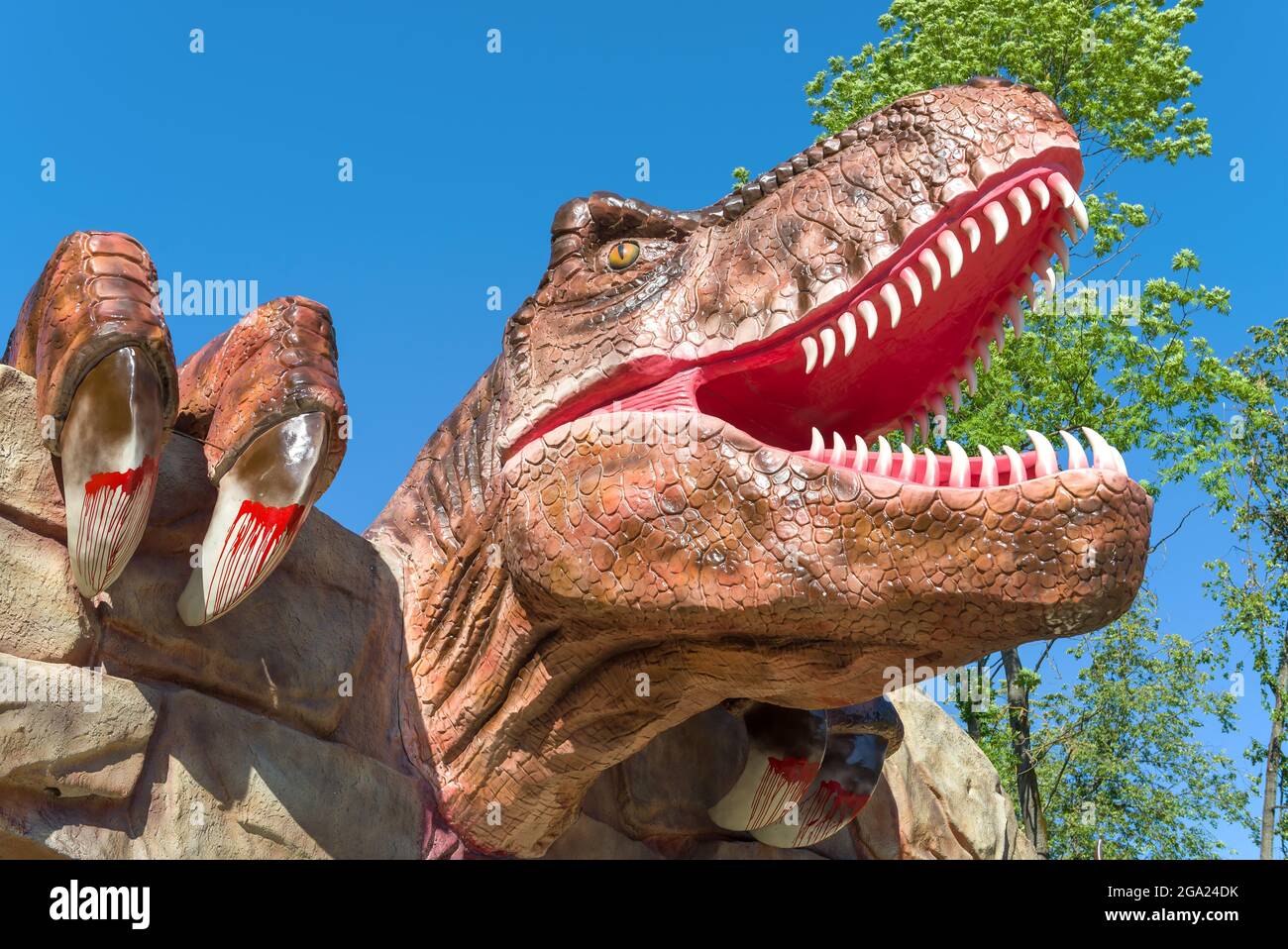 VELIKIE LUKI, RUSSIA - 04 LUGLIO 2021: Capo di un dinosauro carnivoro sopra l'ingresso al Dinopark primo piano in un giorno di sole luglio Foto Stock