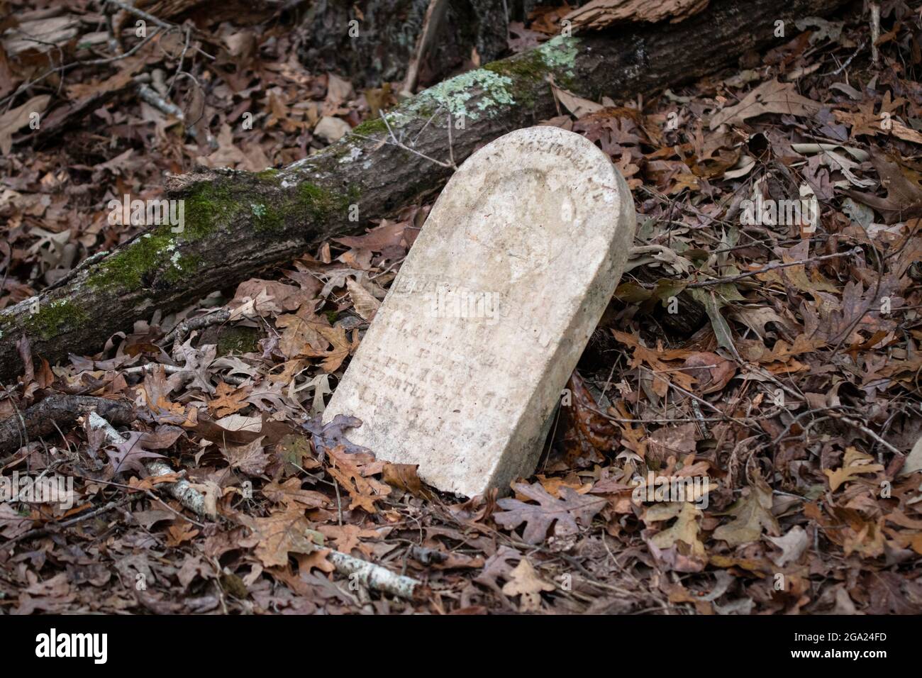 Vecchia lapide del 19 ° secolo indossato con il tempo in un vecchio cimitero sopravento nei boschi in Alabama rurale. Foto Stock