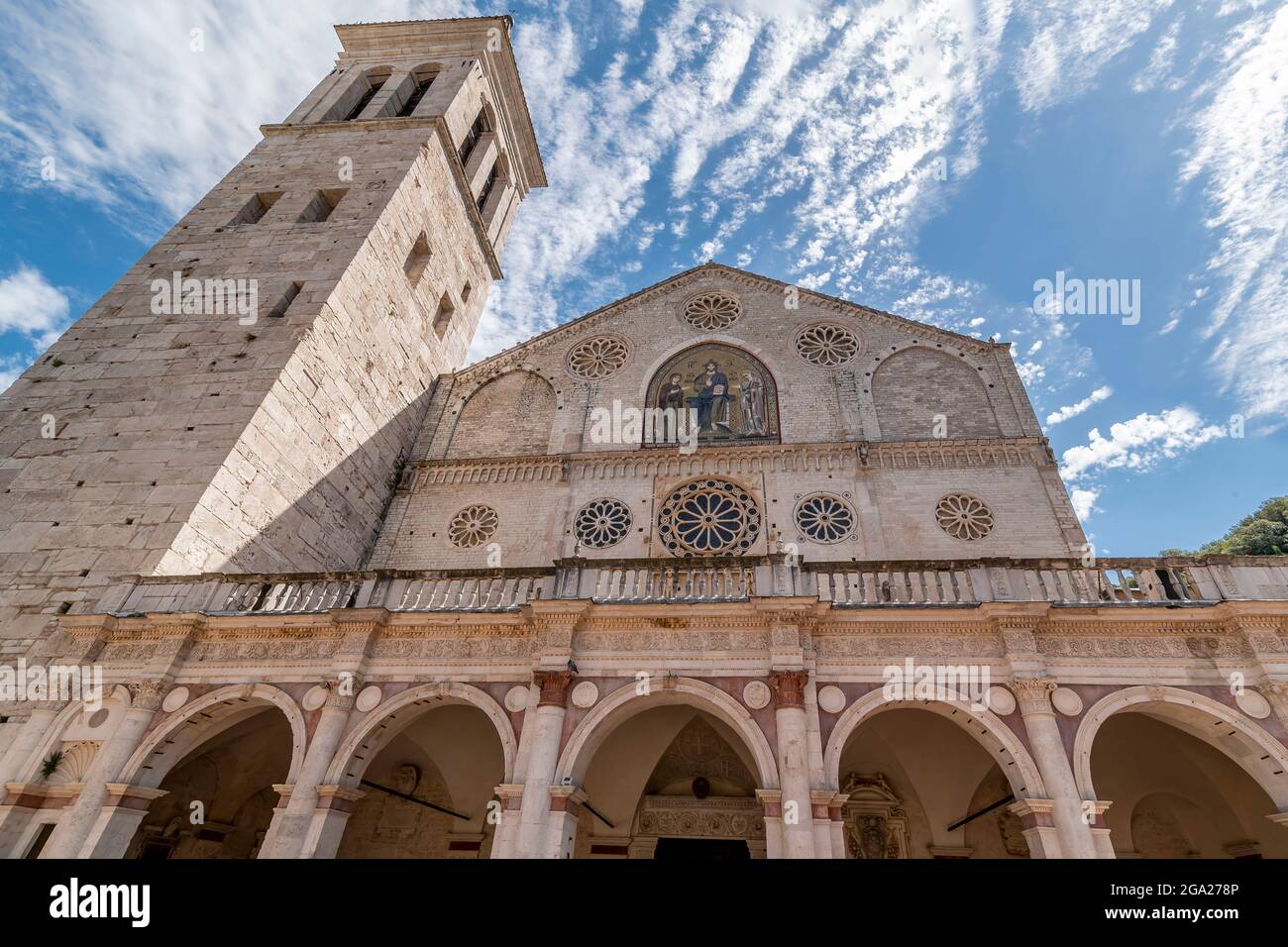 La bella facciata dell'antica cattedrale del Duomo di Santa Maria Assunta a Spoleto, in Italia, contro un cielo drammatico Foto Stock