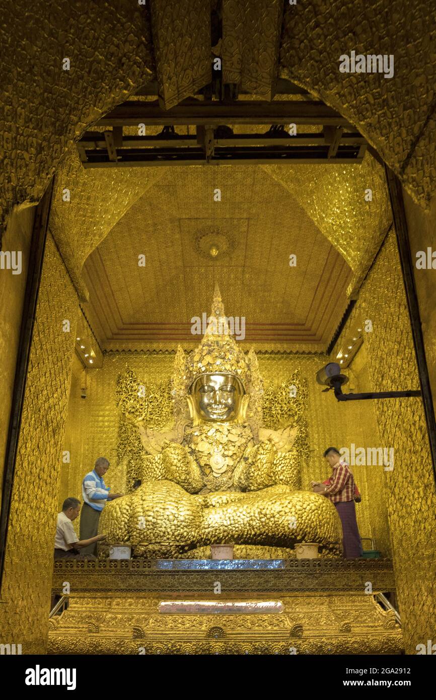 Pellegrini che posano una foglia d’oro sull’immagine del Buddha di Maha Muni, nella Pagoda della Grande Sage, la più importante struttura religiosa di Mandalay, Myanmar-Birmania Foto Stock