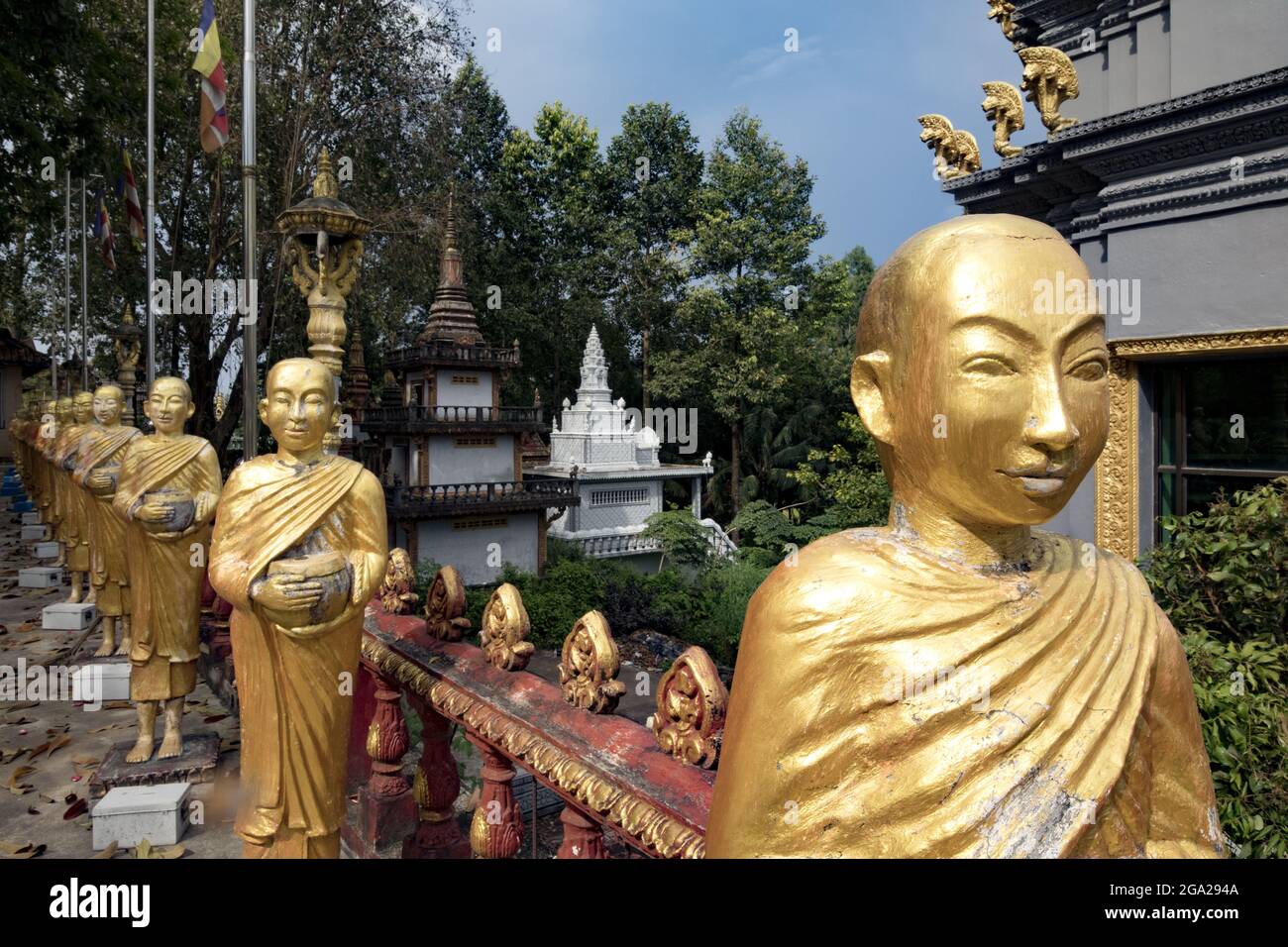 Fila di figure dipinte d'oro di monaci nel monastero buddista a Sihanoukville, Cambogia; Krong Preah Sihanouk, Sihanoukville, Cambogia Foto Stock