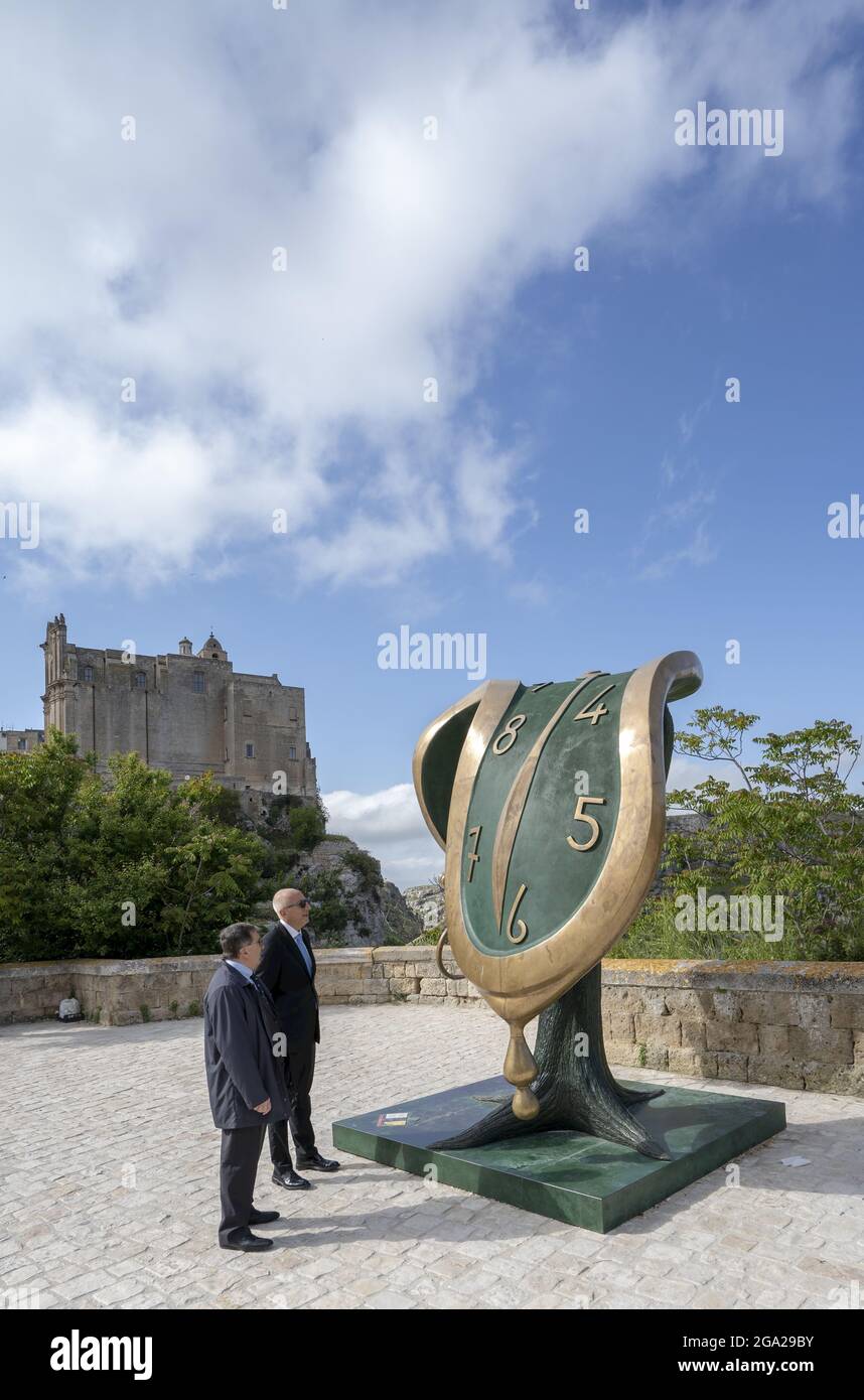 Due uomini maturi si levano in piedi guardando la scultura unica dell'orologio, Danza del tempo II, la mostra Salvador Dali a Matera, Basilicata, durante 2019 europeo... Foto Stock