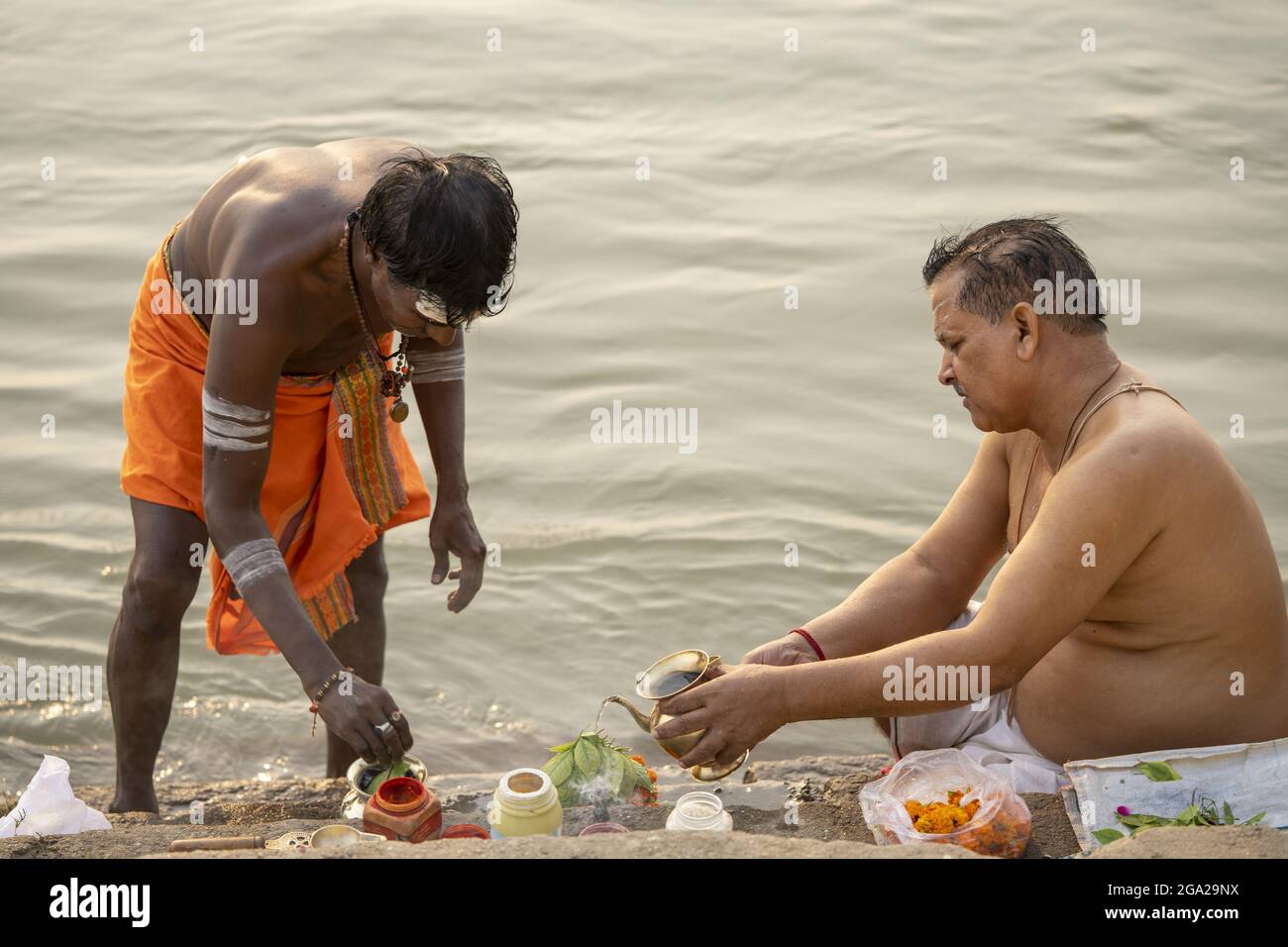 Prete che esegue una puja indù sulla riva del fiume Gange; Varanasi, Uttar Pradesh, India Foto Stock