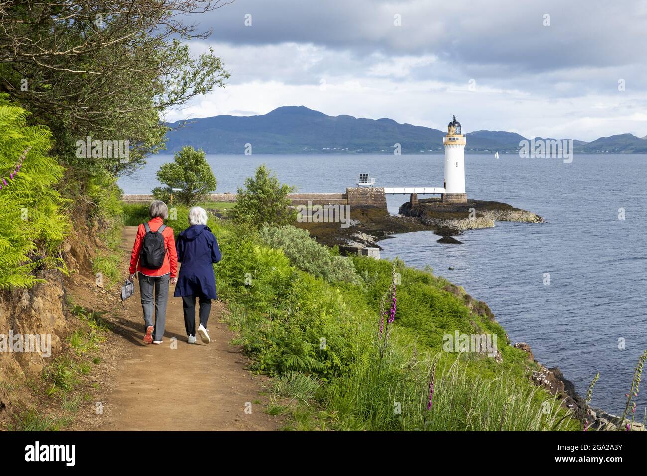 Due donne camminano verso il faro Rubha nan Gall (Stevenson) vicino a Tobermory, Scozia; Tobermory, Isola di Mull, Scozia Foto Stock