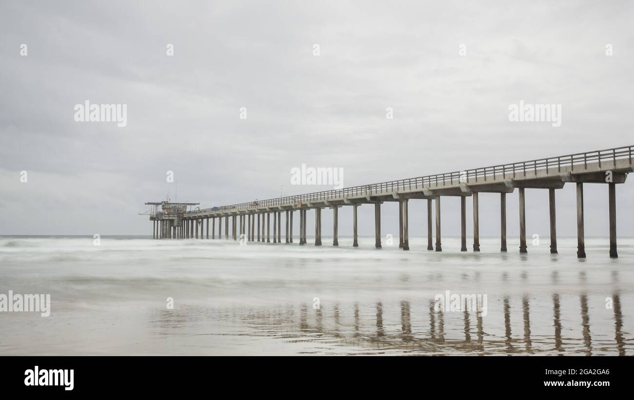 La lunga distesa dell'iconico Scripps Pier nell'Oceano Pacifico vicino a San Diego in una giornata grigia Foto Stock