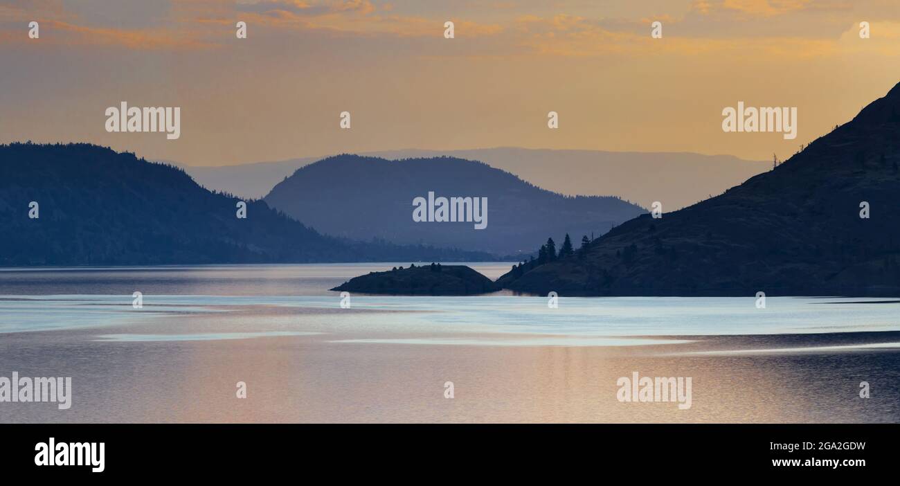 Tranquillo tramonto dorato sul lago Okanagan; British Columbia, Canada Foto Stock