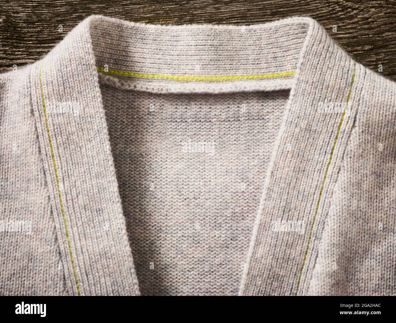 Colletto e colletto di un maglione cardigan grigio con cuciture gialle; studio Foto Stock
