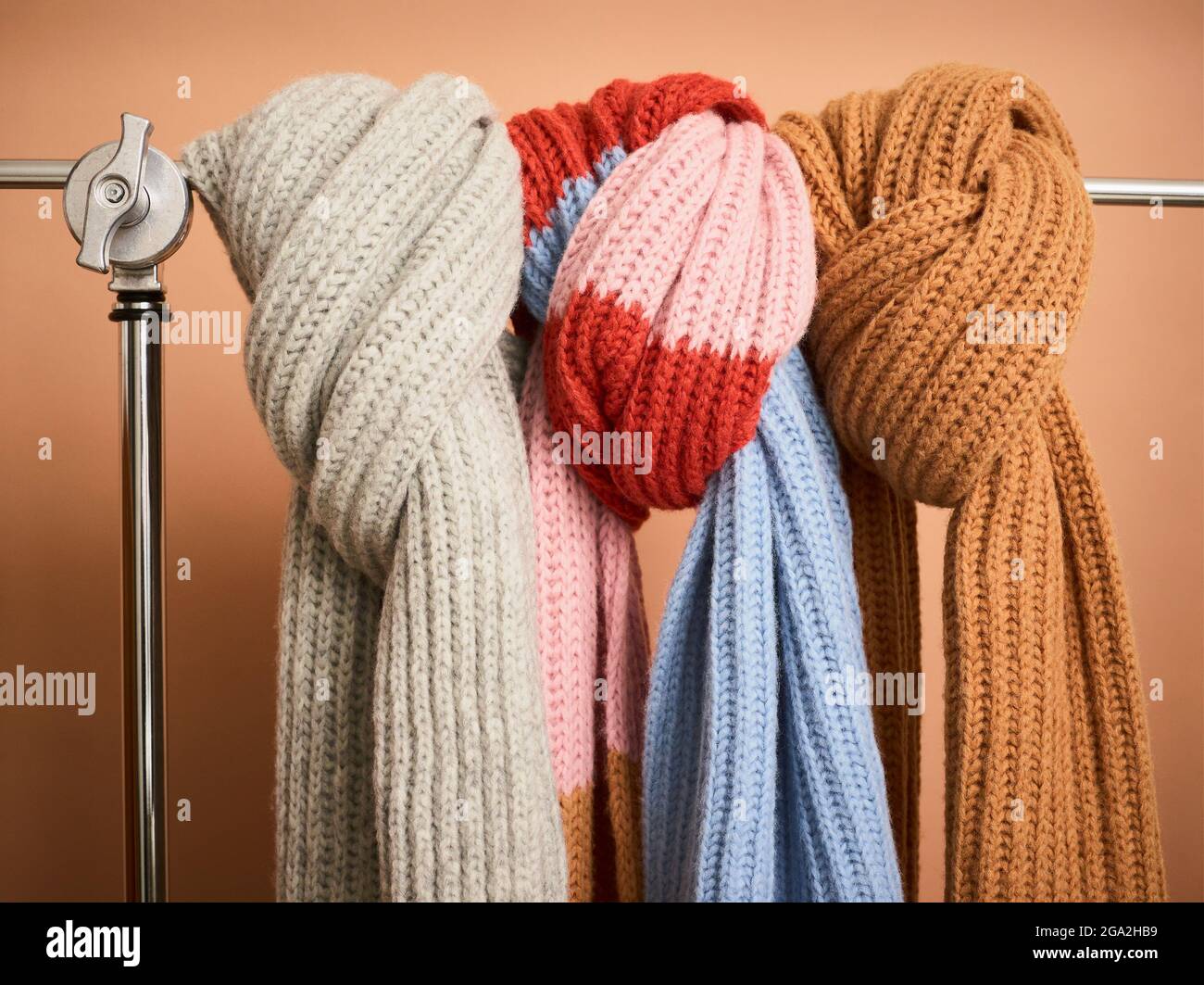 Sciarpe in maglia legate in mostra su un rack in metallo; Studio Foto Stock