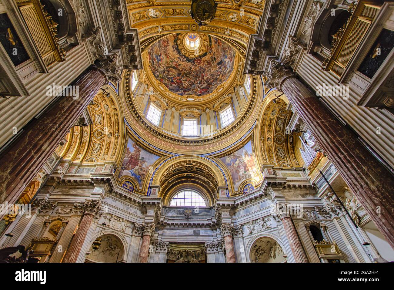 Magnifico interno di Sant'Agnese nella chiesa cattolica di Agone con finestre ad arco dorate e soffitto a cupola ornato; Roma Lazio, Italia Foto Stock