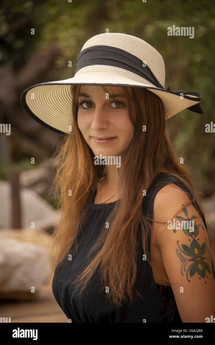 Primo piano ritratto di donna con un tatuaggio sul braccio che indossa un cappello di paglia e sorride alla macchina fotografica al Gabus Game Ranch Foto Stock