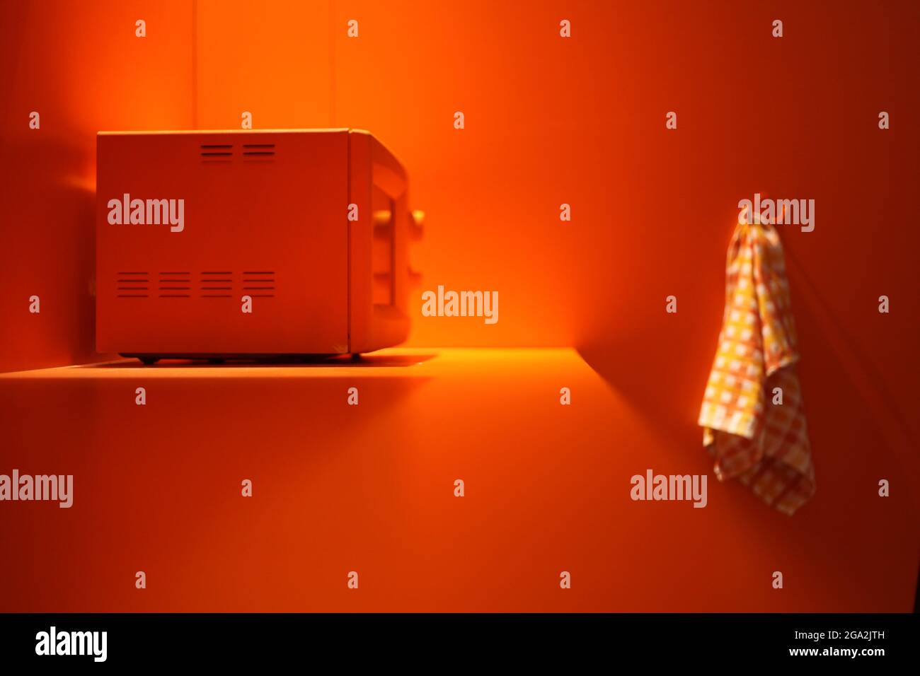 forno a microonde arancione nella cucina arancione con asciugamano bianco.  tecnologia concetto - riscaldamento di energia nel forno a microonde Foto  stock - Alamy