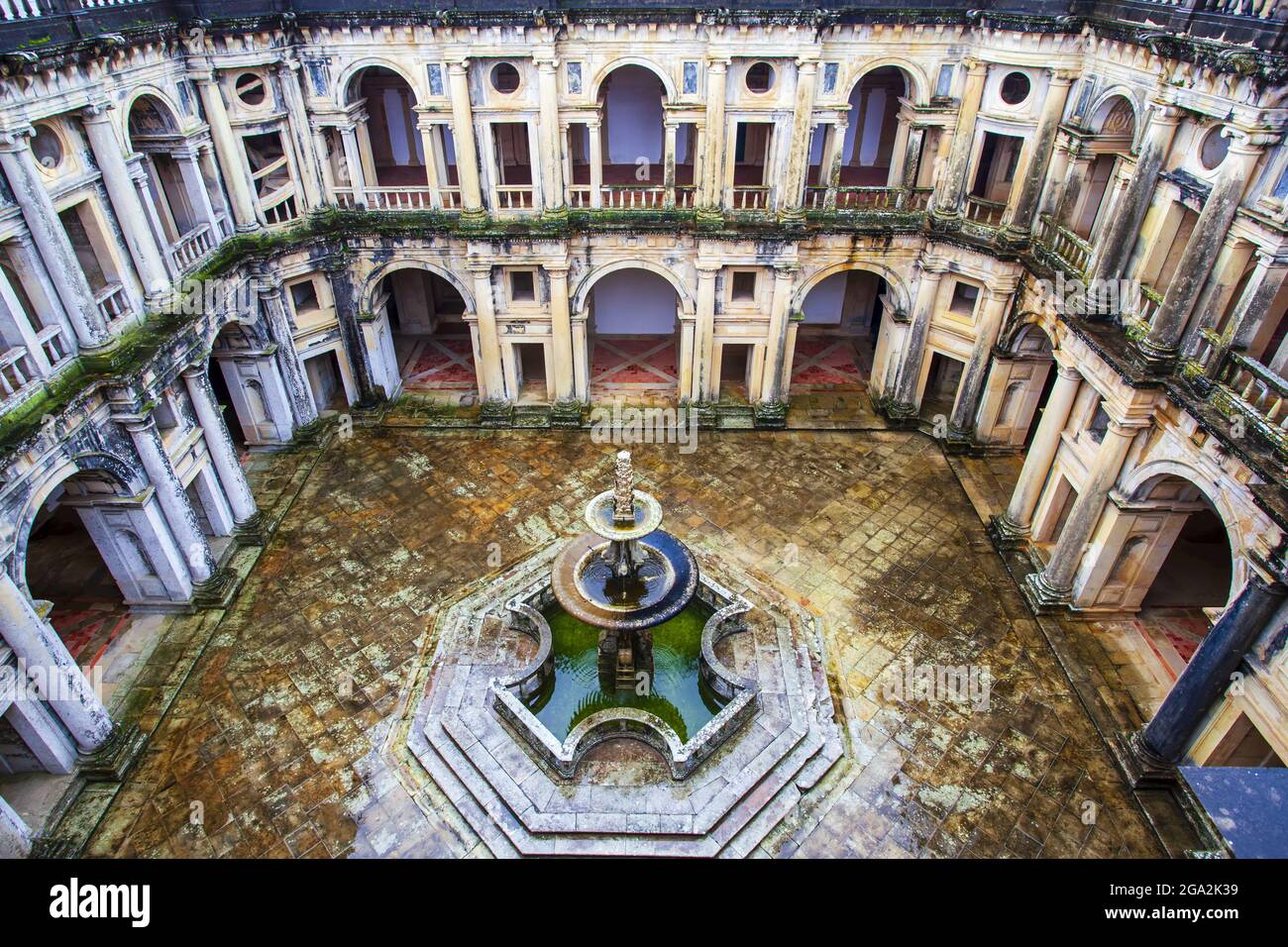 Guardando verso il basso il cortile interno con più archi e ingressi che circondano una fontana centrale al chiostro re Joao III nel ... Foto Stock