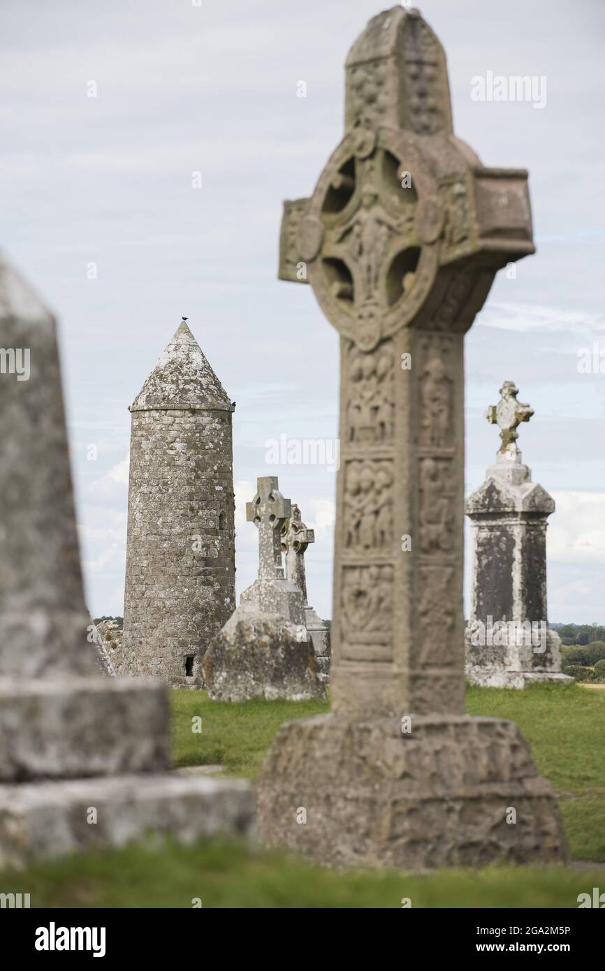 Antico monastero di Clonmacnoise con il suo sepoltura di monumenti in pietra e croci celtiche sulle rive del fiume Shannon; Contea di Offaly, Irlanda Foto Stock