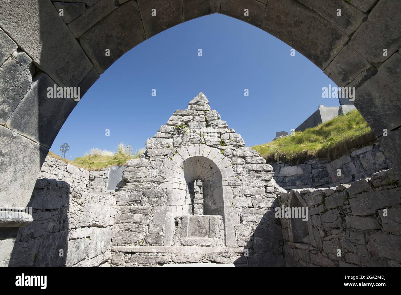 All'interno della Chiesa di Saint Caomhan (Chiesa Sunken) su Inishear, (Inis Oirr) guardando verso l'alto un cielo blu dalle antiche rovine di pietra Foto Stock