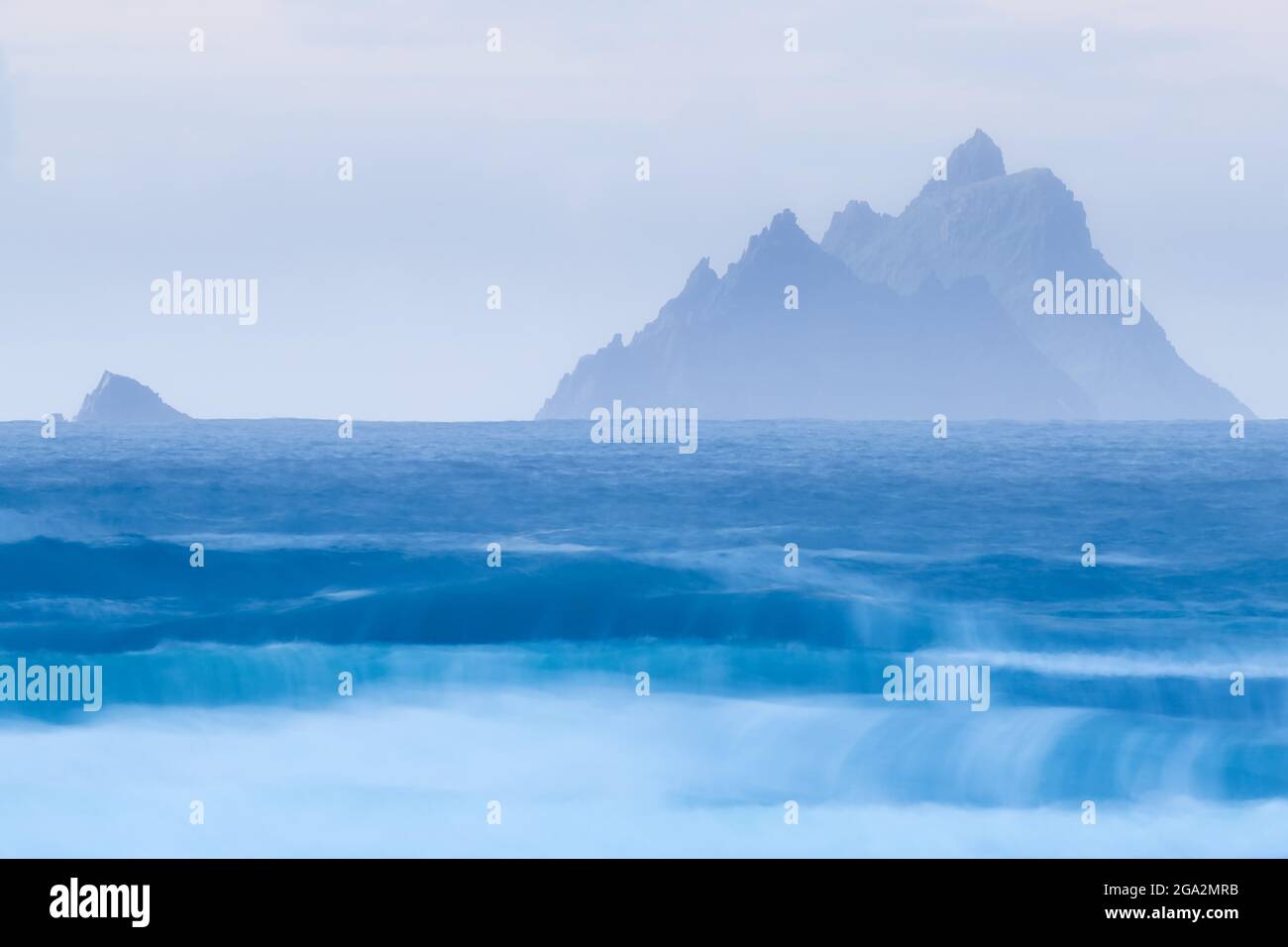 L'Oceano Atlantico settentrionale ondeggia con un cielo azzurro sulle isole Skellig, mostrando le frastagliate scogliere di Skellig Michael e Little Skellig Foto Stock