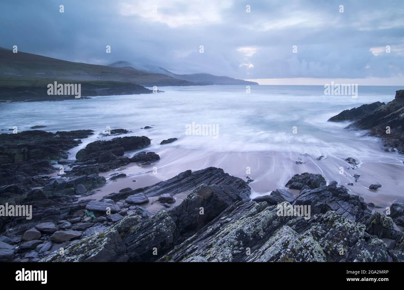 Ripiano roccioso costiero sulla spiaggia con un cielo tempestoso a St Finian's Bay (The Glen) sull'Oceano Atlantico lungo lo Skellig Ring; County Kerry, Irlanda Foto Stock