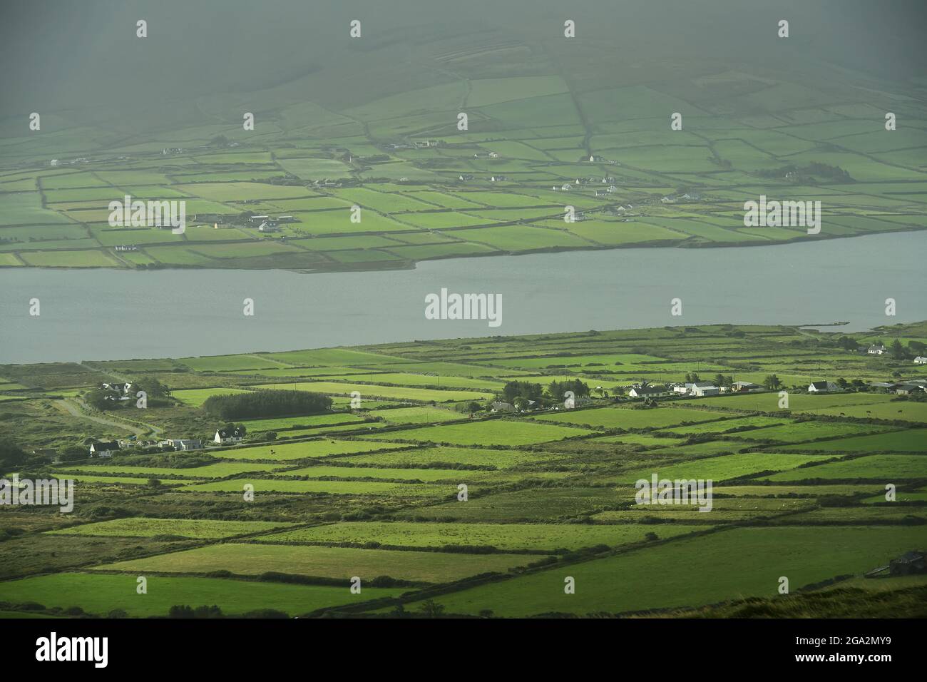 Vista aerea della lussureggiante campagna a Portmagee sulla penisola di Iveragh e attraverso il canale per l'isola di Valentia in una giornata di sole Foto Stock