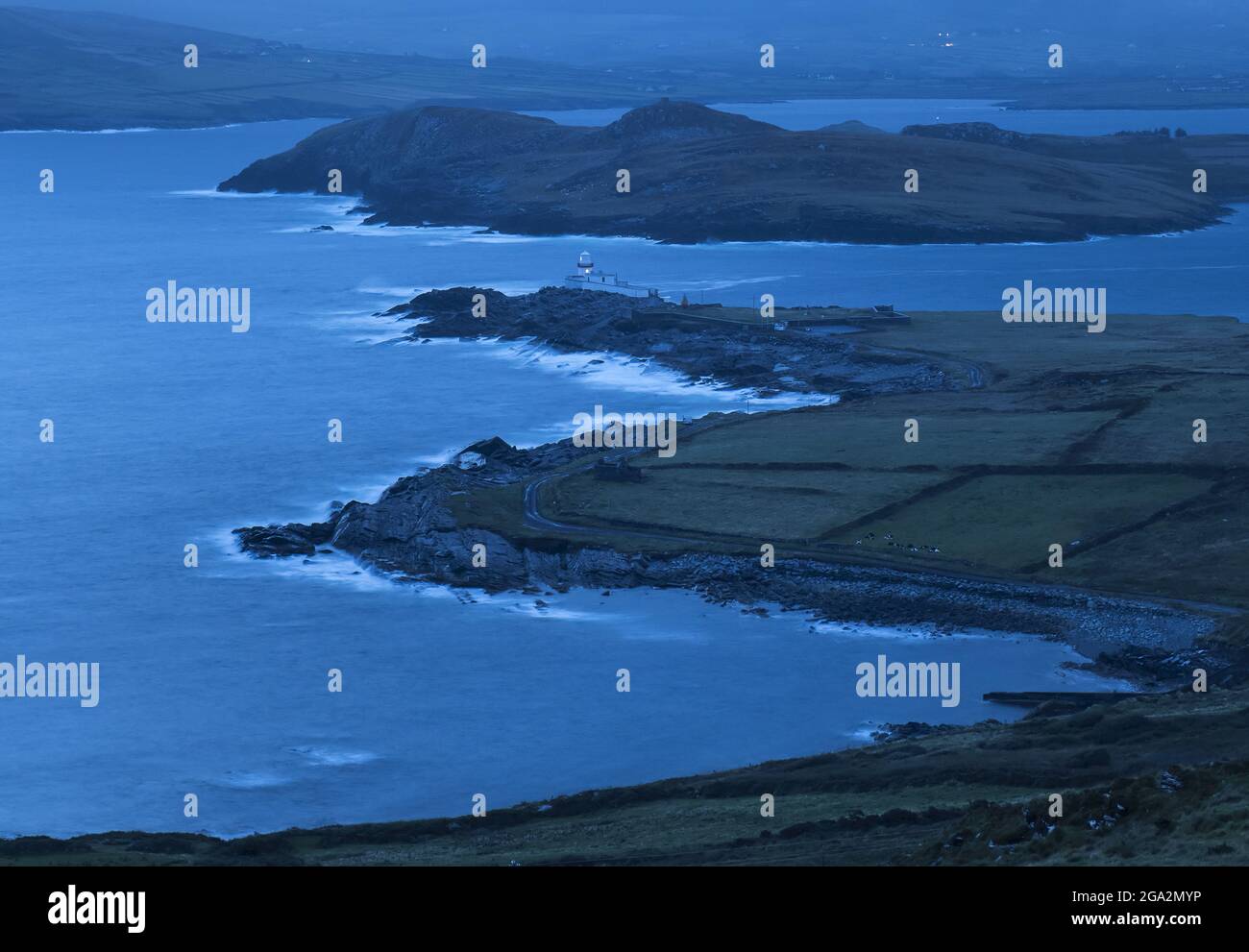 Vista aerea delle onde che si infrangono nelle ore precedenti l'alba a Valentia Island Lighthouse a Cromwell Point, costruito sul sito del 17th secolo Cromwell ... Foto Stock